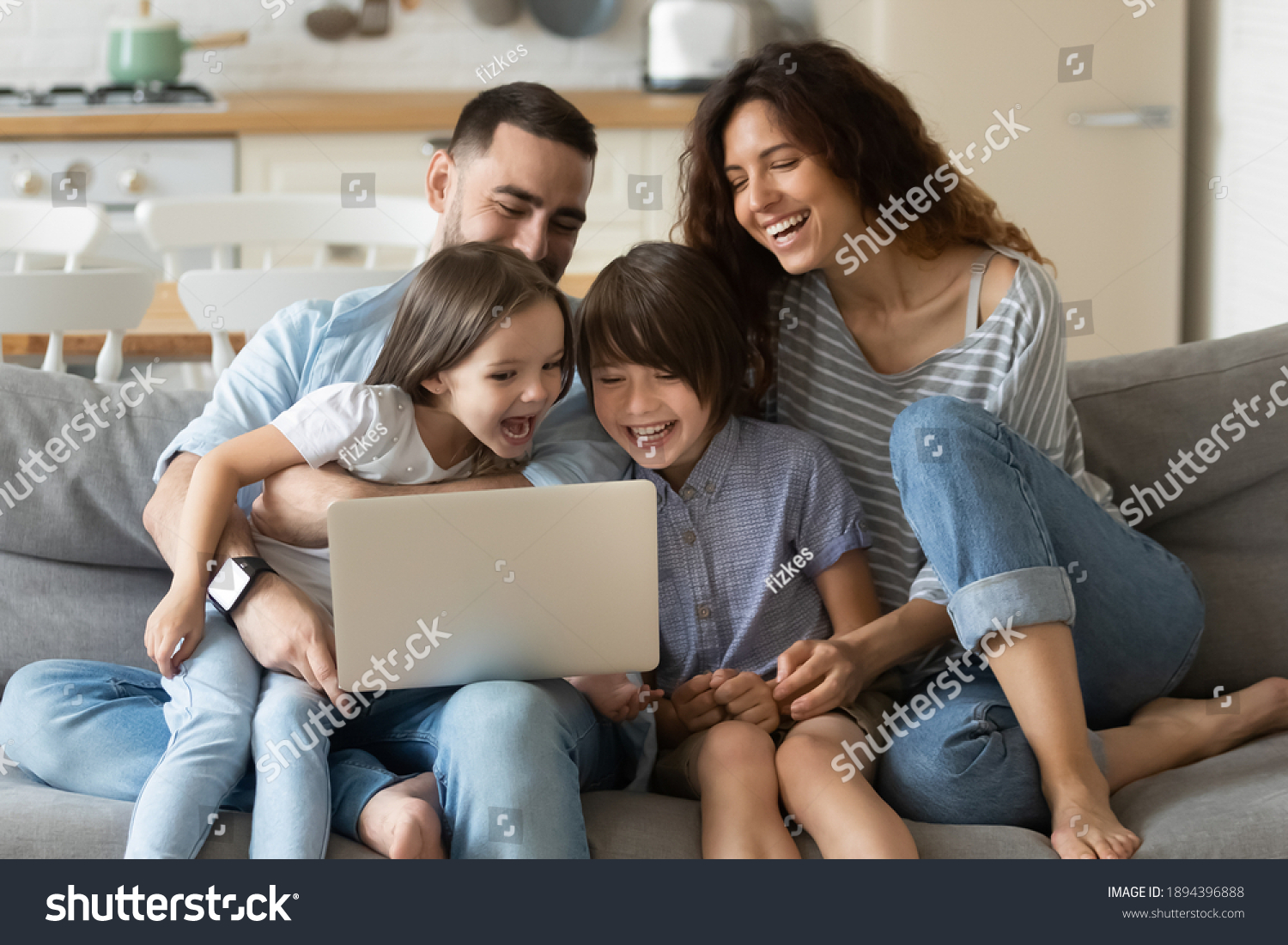 Close up happy parents with daughter and son using laptop sitting on couch at home. Smiling mother, father and cute children looking at laptop screen using video call. Family having fun with computer. #1894396888