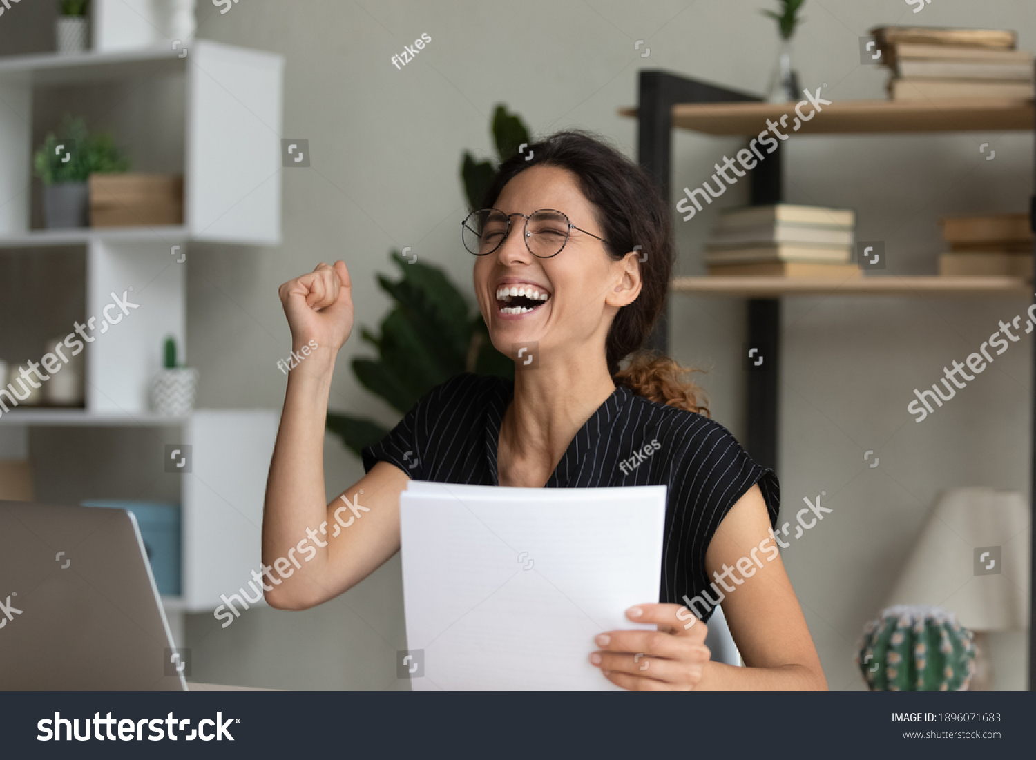Overjoyed millennial Caucasian woman feel euphoric reading good news in post paper letter. Happy excited young female in glasses triumph receive amazing message in postal paperwork or correspondence. #1896071683