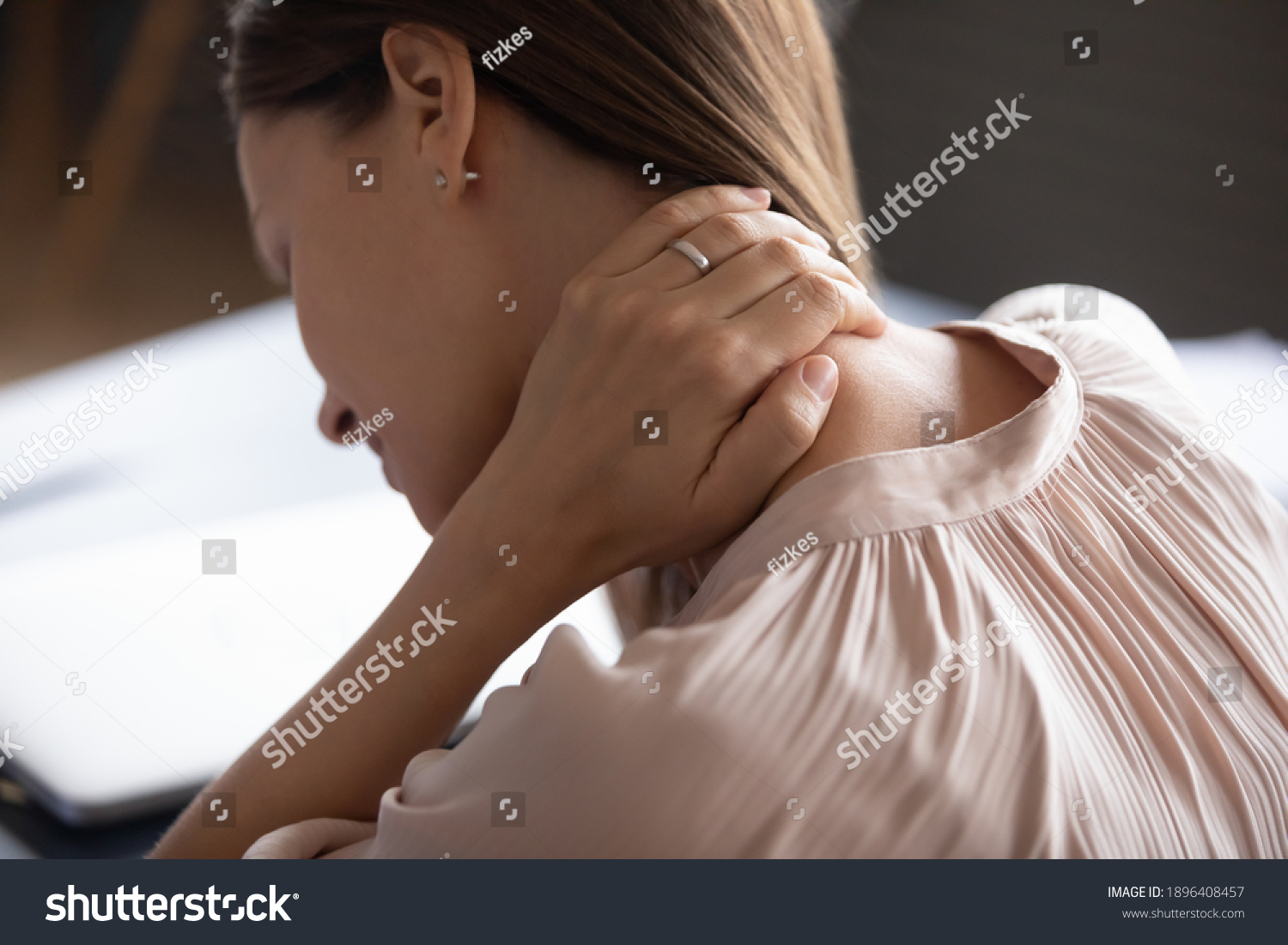 Close up exhausted woman touching massaging tensed neck muscles, feeling unwell after long hours sedentary work, uncomfortable chair, incorrect posture, young female suffering from pain, ache #1896408457