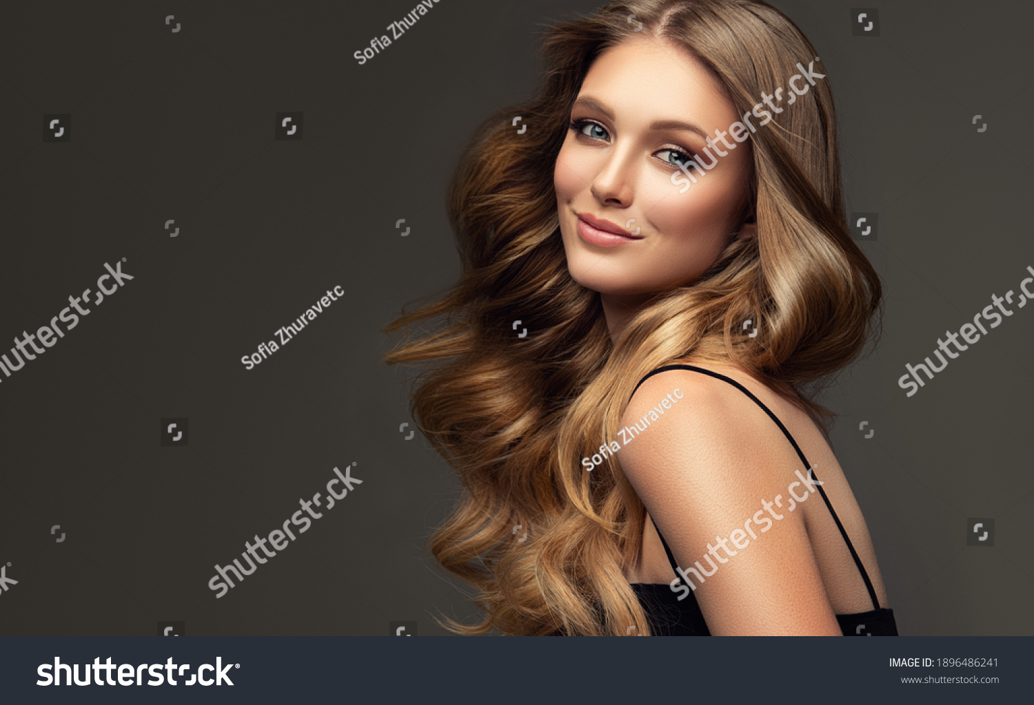 Beauty blonde girl with long  and   shiny wavy  hair .  Beautiful   woman model with curly hairstyle . Fashion, cosmetics and makeup #1896486241