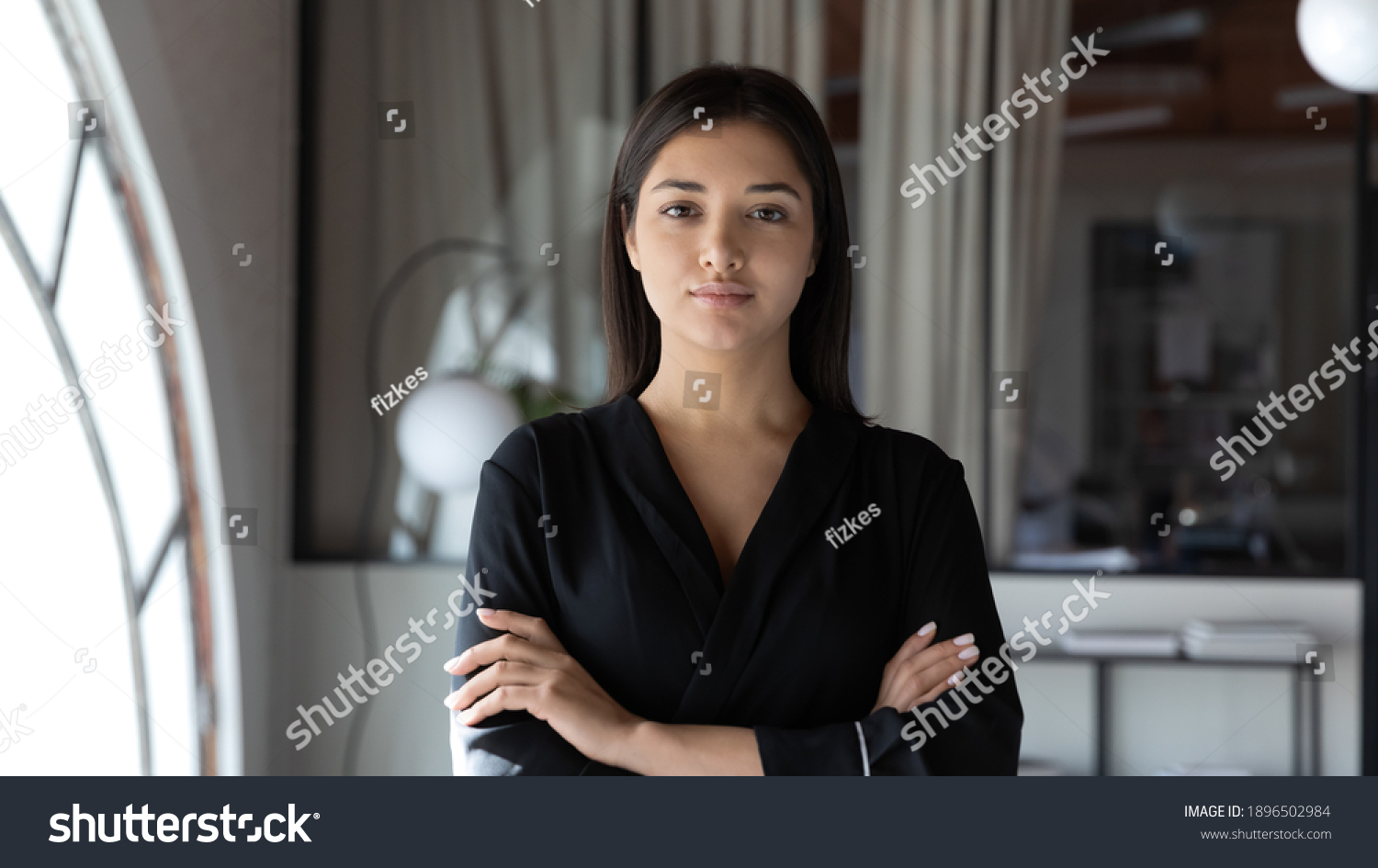 Head shot portrait confident Indian businesswoman hr manager standing in modern office with arms crossed, serious entrepreneur team leader mentor posing for corporate photo, looking at camera #1896502984