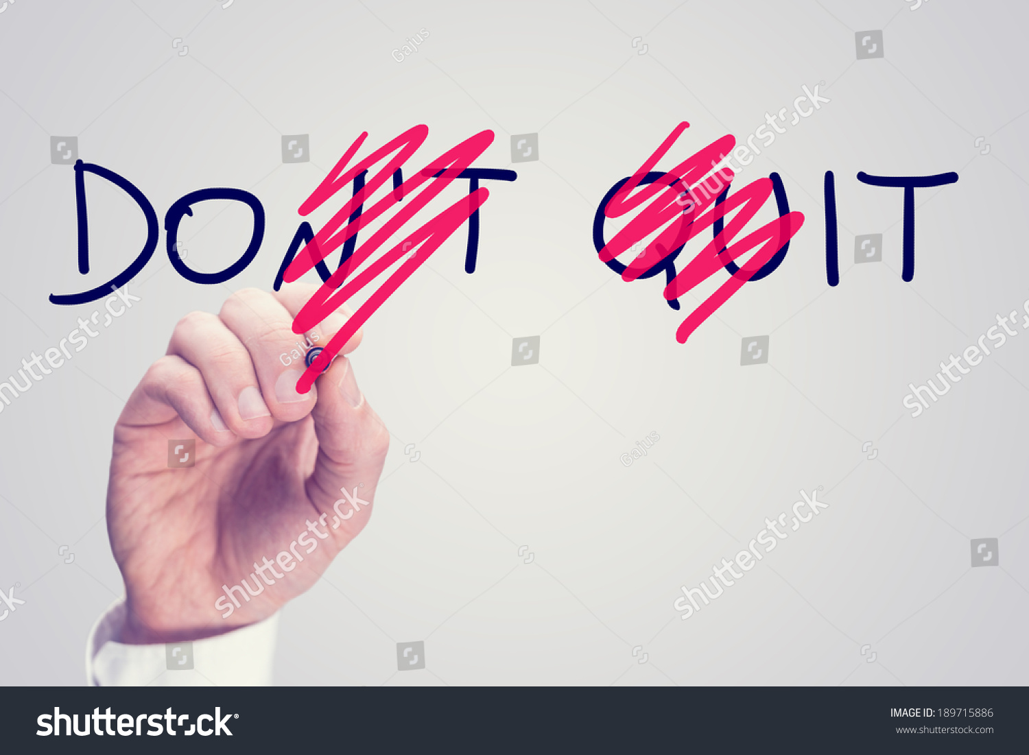 Don't Quit - Do It, conceptual image with a man scrubbing through letters in the words Don't Quit converting them to Do It with a red pen in a motivational message of hope and perseverance. #189715886