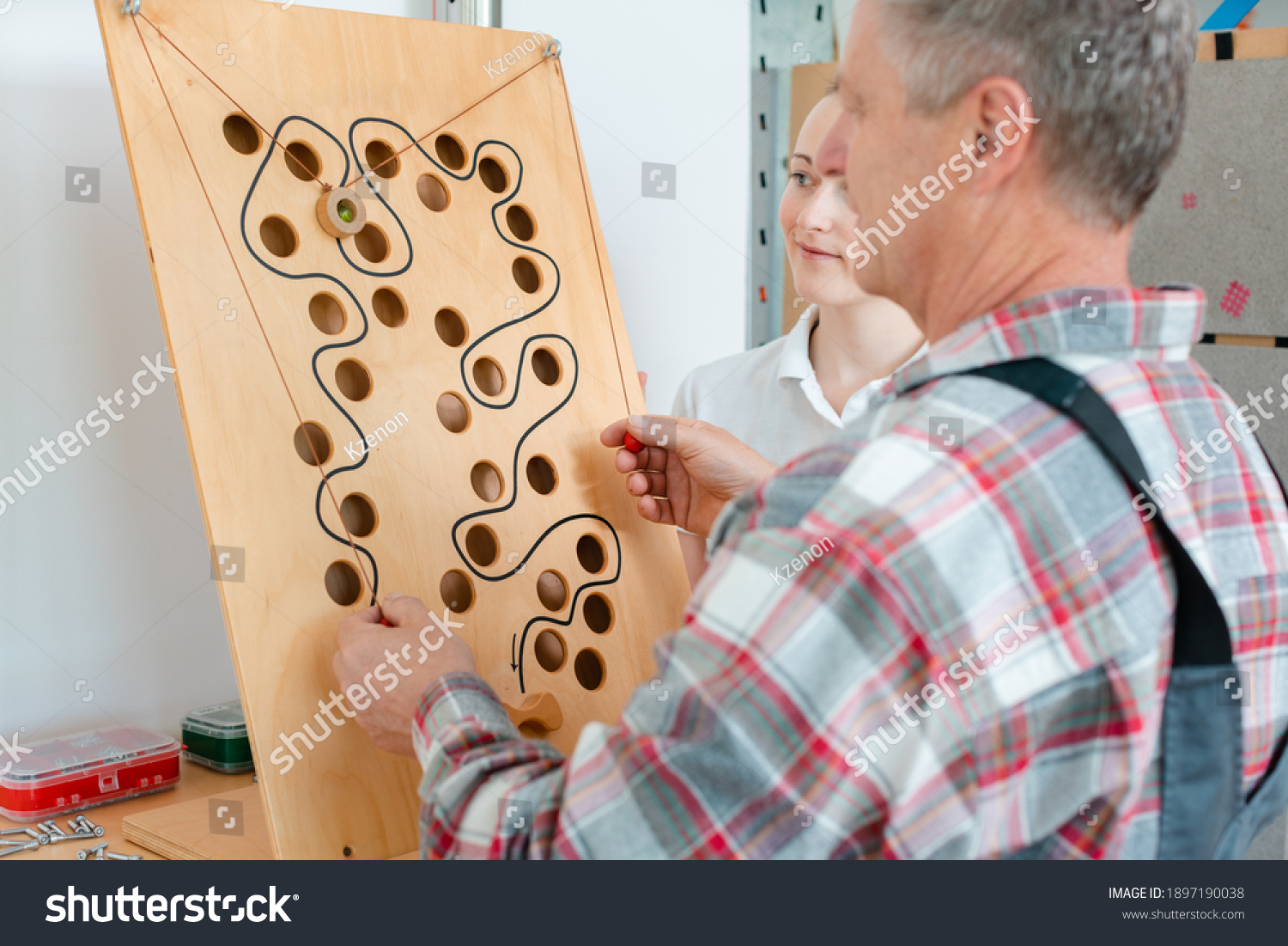 Man with therapist in occupational therapy testing his dexterity on a game board #1897190038