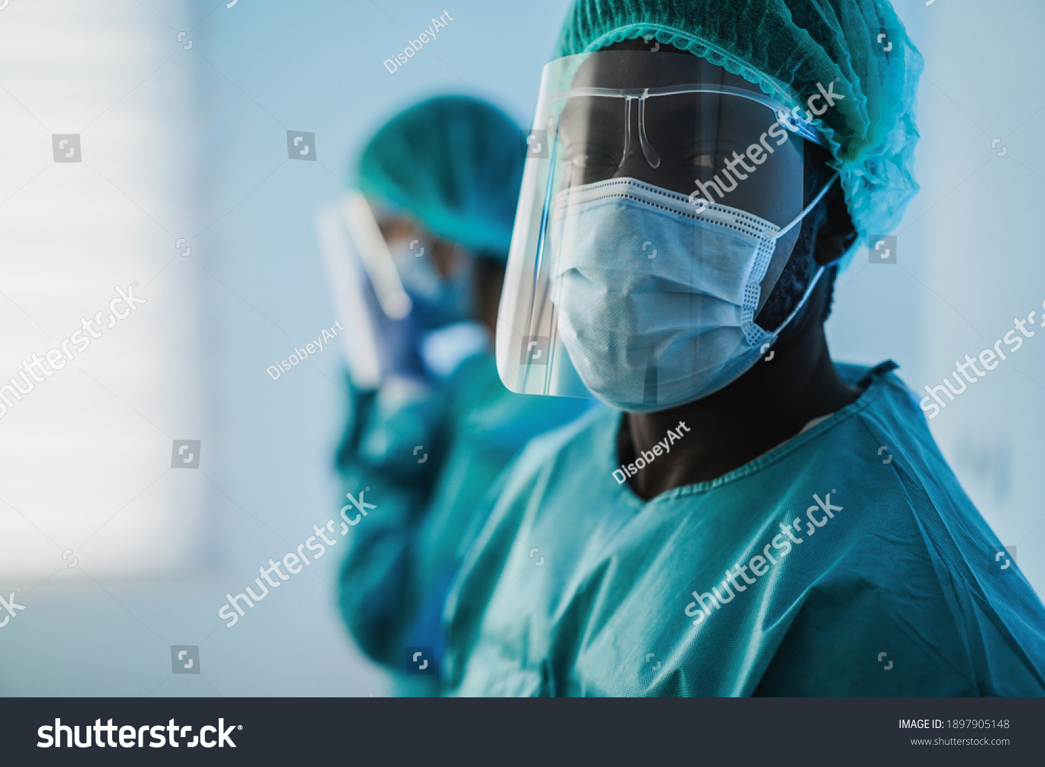 Men doctors at work inside hospital during coronavirus outbreak - Medical worker on Covid-19 crisis wearing face protective mask - Focus on mask #1897905148