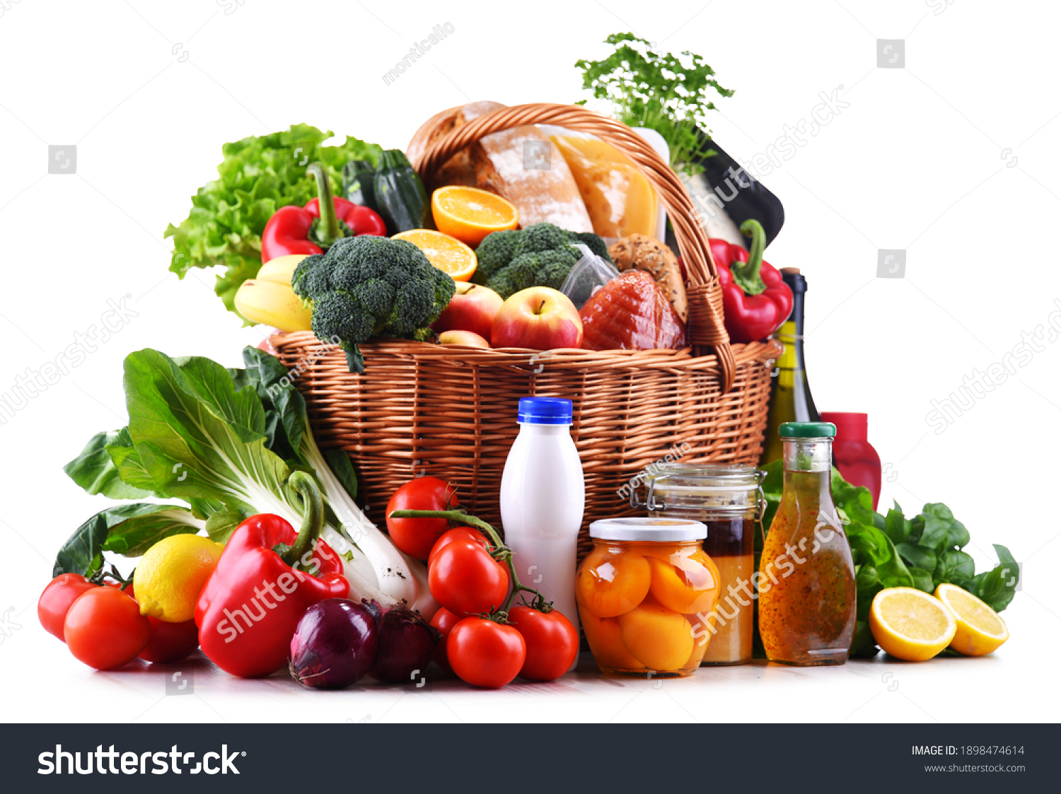 Wicker basket with assorted grocery products including fresh vegetables and fruits #1898474614