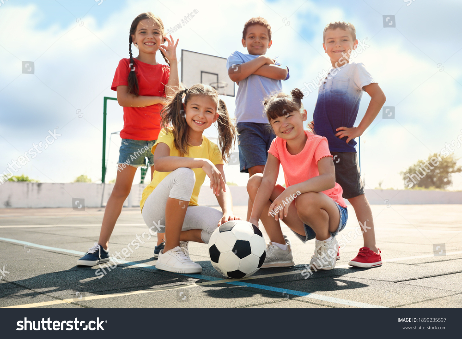 Cute children with soccer ball at sports court on sunny day. Summer camp #1899235597