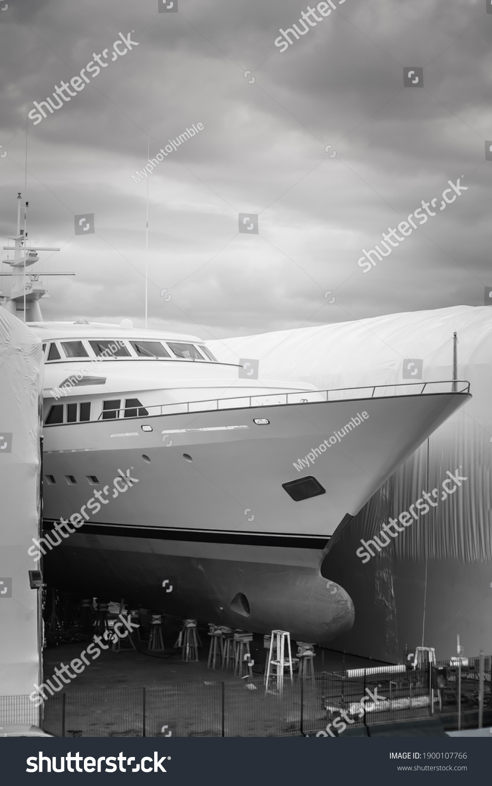 Black and White photo of a hauled out vessel undergoing winter maintenance in shipyard #1900107766