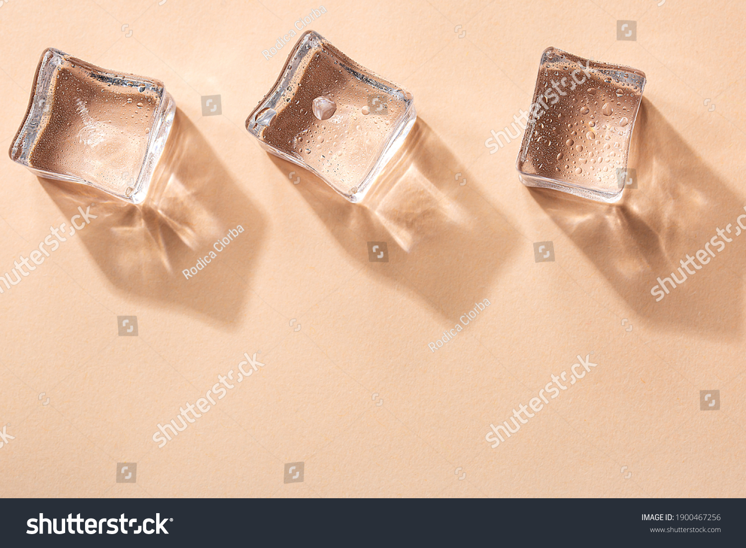 Three Ice cubes on pastel peach color background. Concept art. Minimal surrealism. Flat lay with copy space. Soft focus. #1900467256