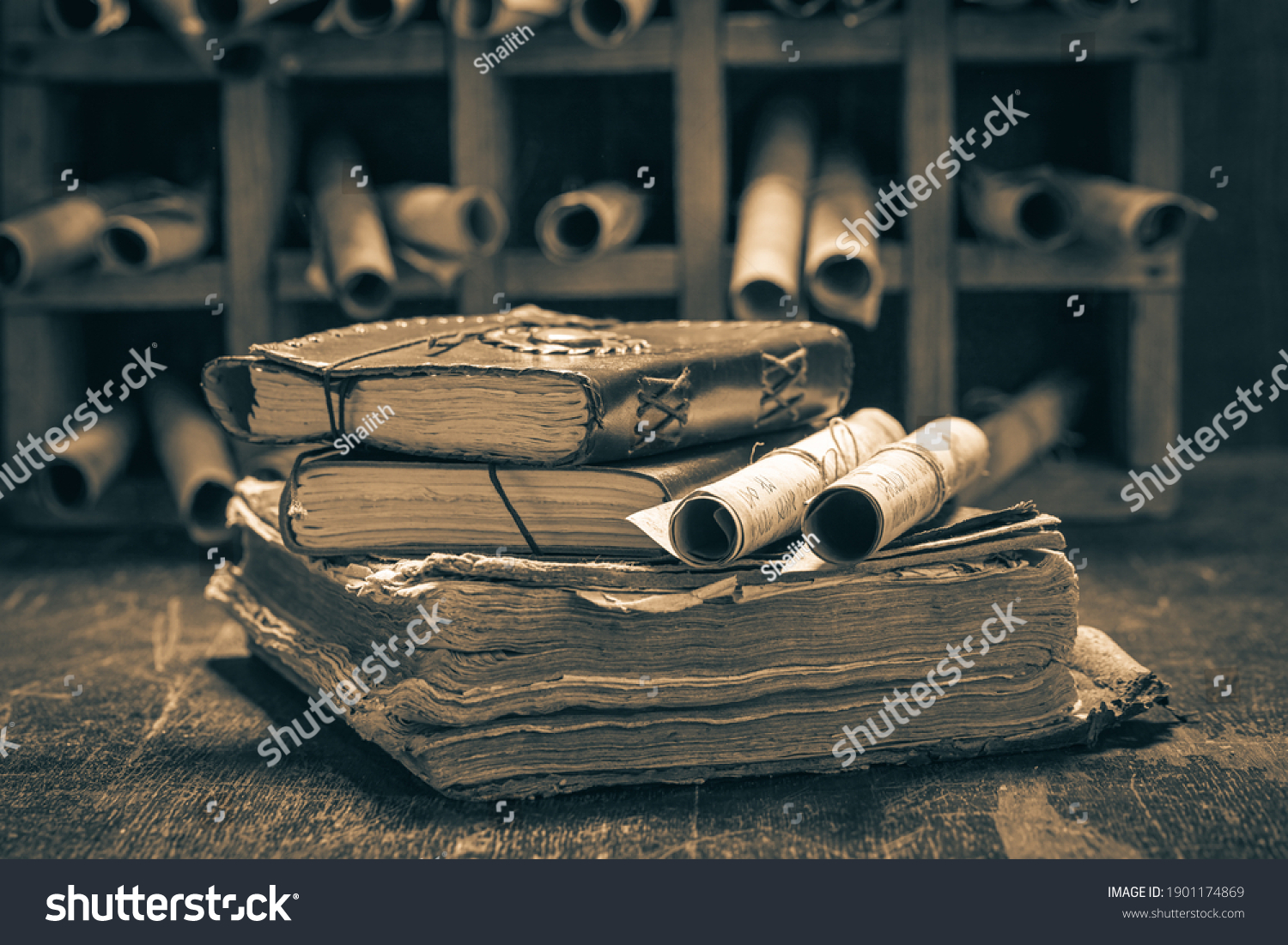 Old books and antique scrolls in library on wooden table #1901174869