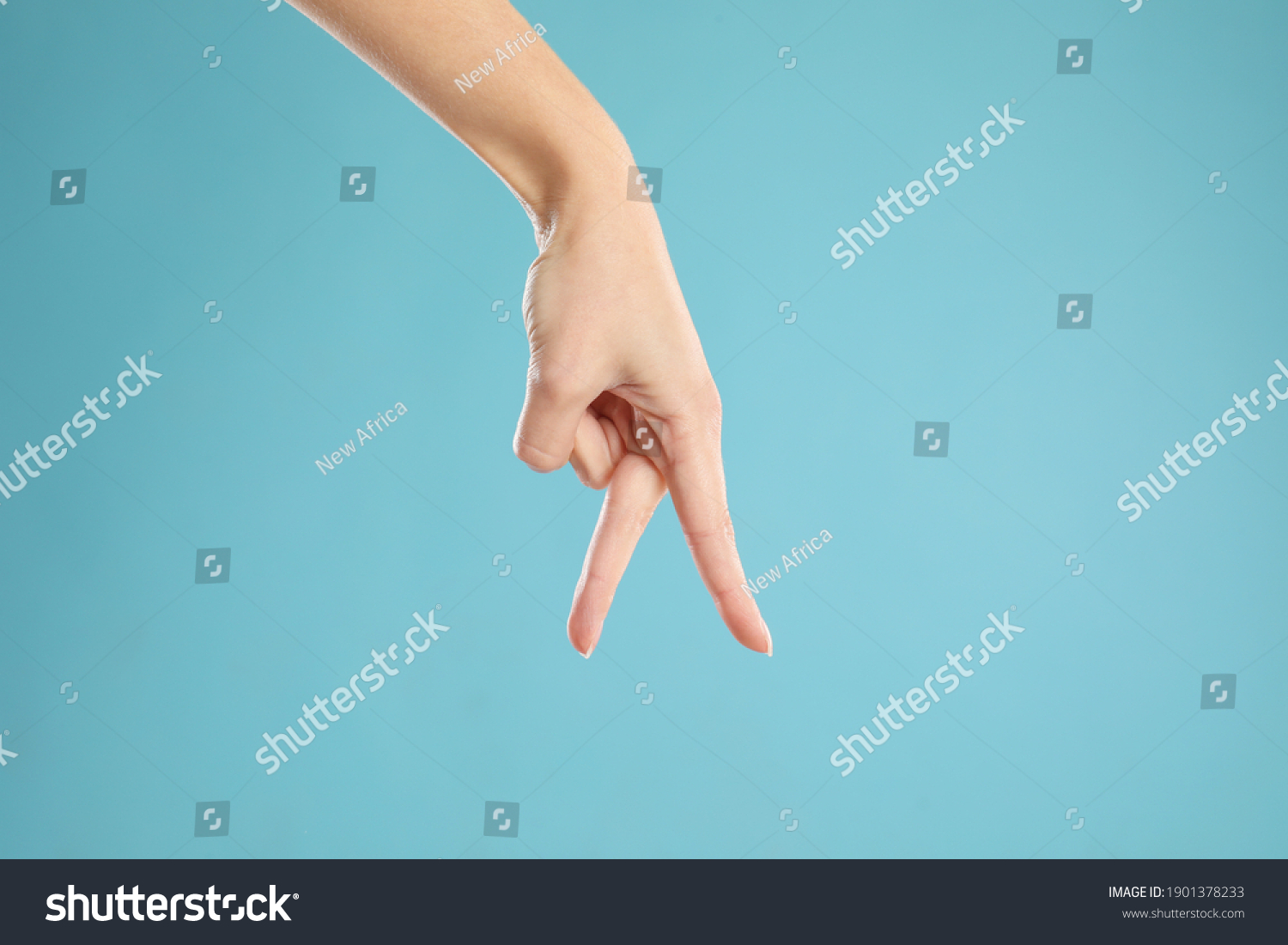 Woman imitating walk with hand on light blue background, closeup. Finger gesture #1901378233