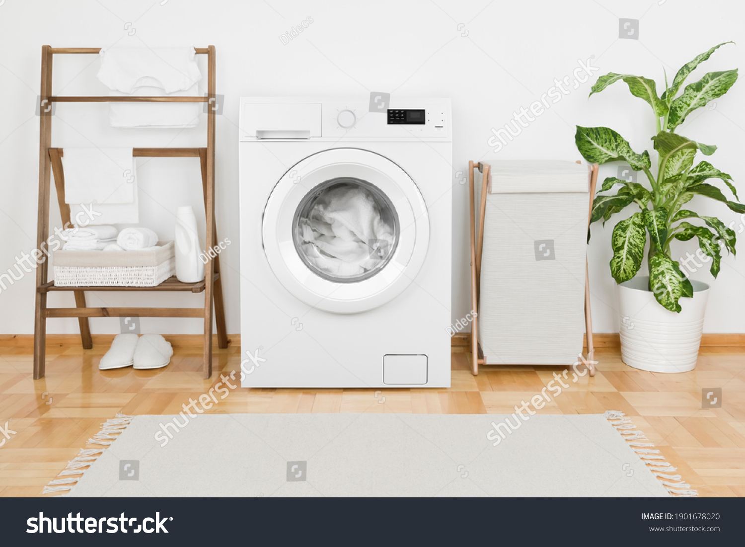 Interior of laundry room with modern washing machine and textile #1901678020