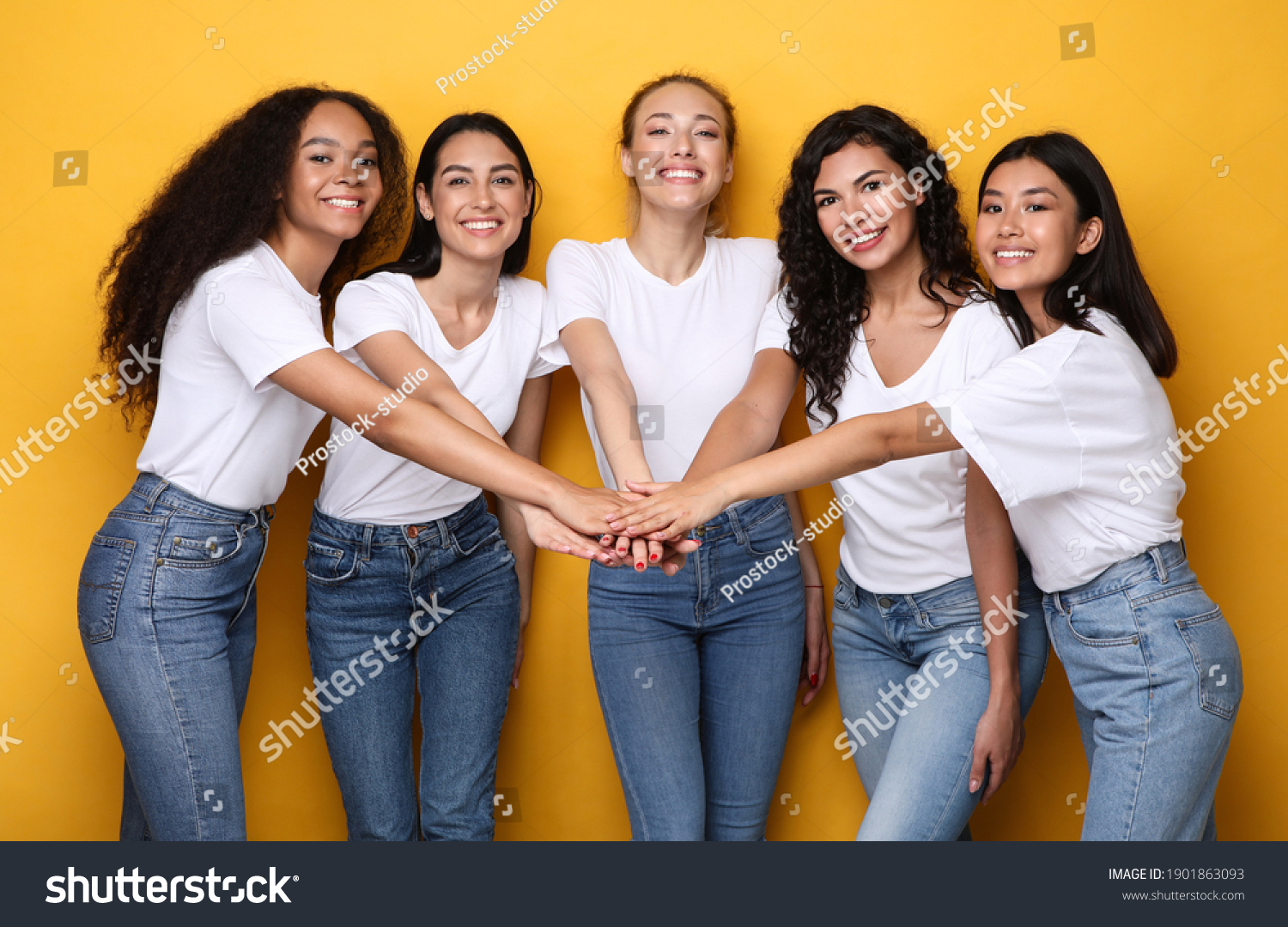 Five Cheerful Diverse Women Holding Hands Standing On Yellow Studio Background, Smiling To Camera. Female Unity And Friendship, Togetherness And Teamwork Concept #1901863093