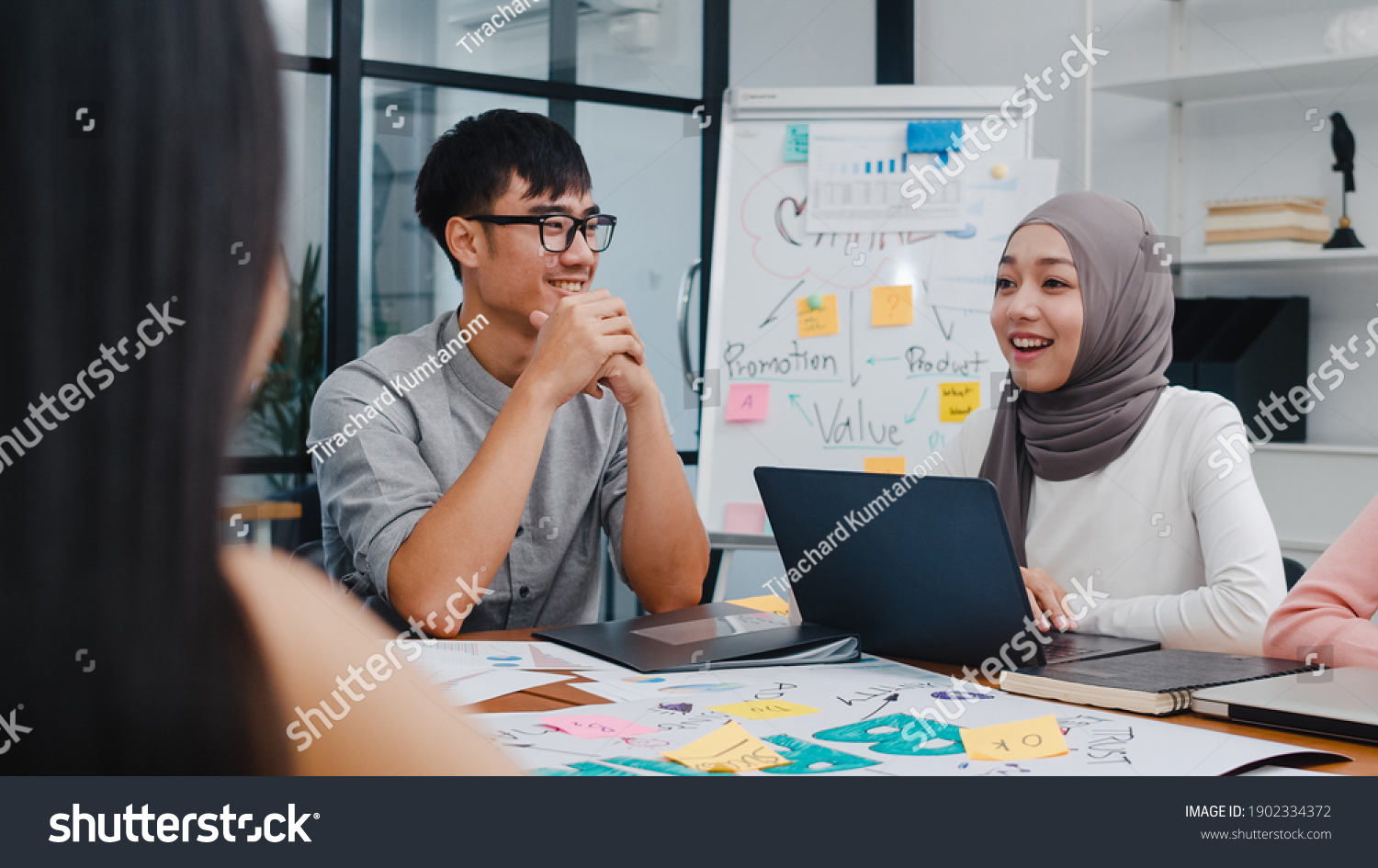 Multiracial group of young creative people in smart casual wear discussing business brainstorming meeting ideas mobile application software design project in modern office. Coworker teamwork concept. #1902334372
