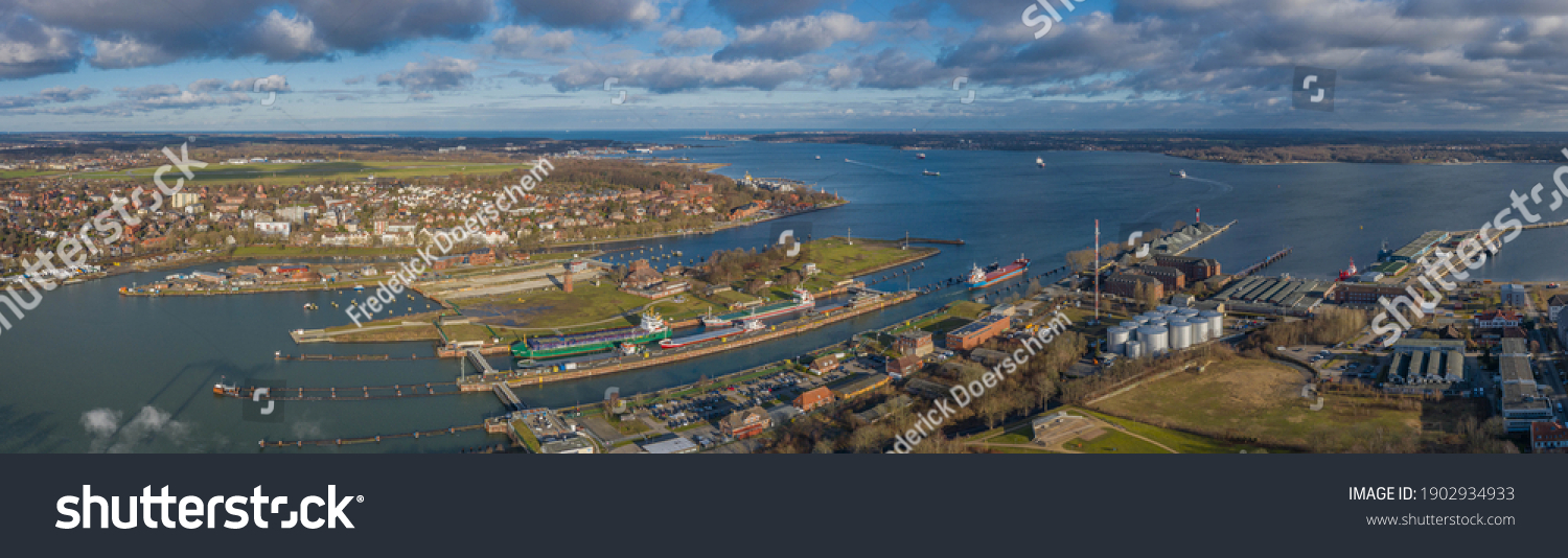Panorama aerial view of the Kiel Canal waterway with lockage Holtenau. Cargo ships pass the Holtenau lock of the Kiel Canal. Industrial area at the Kiel Canal. #1902934933