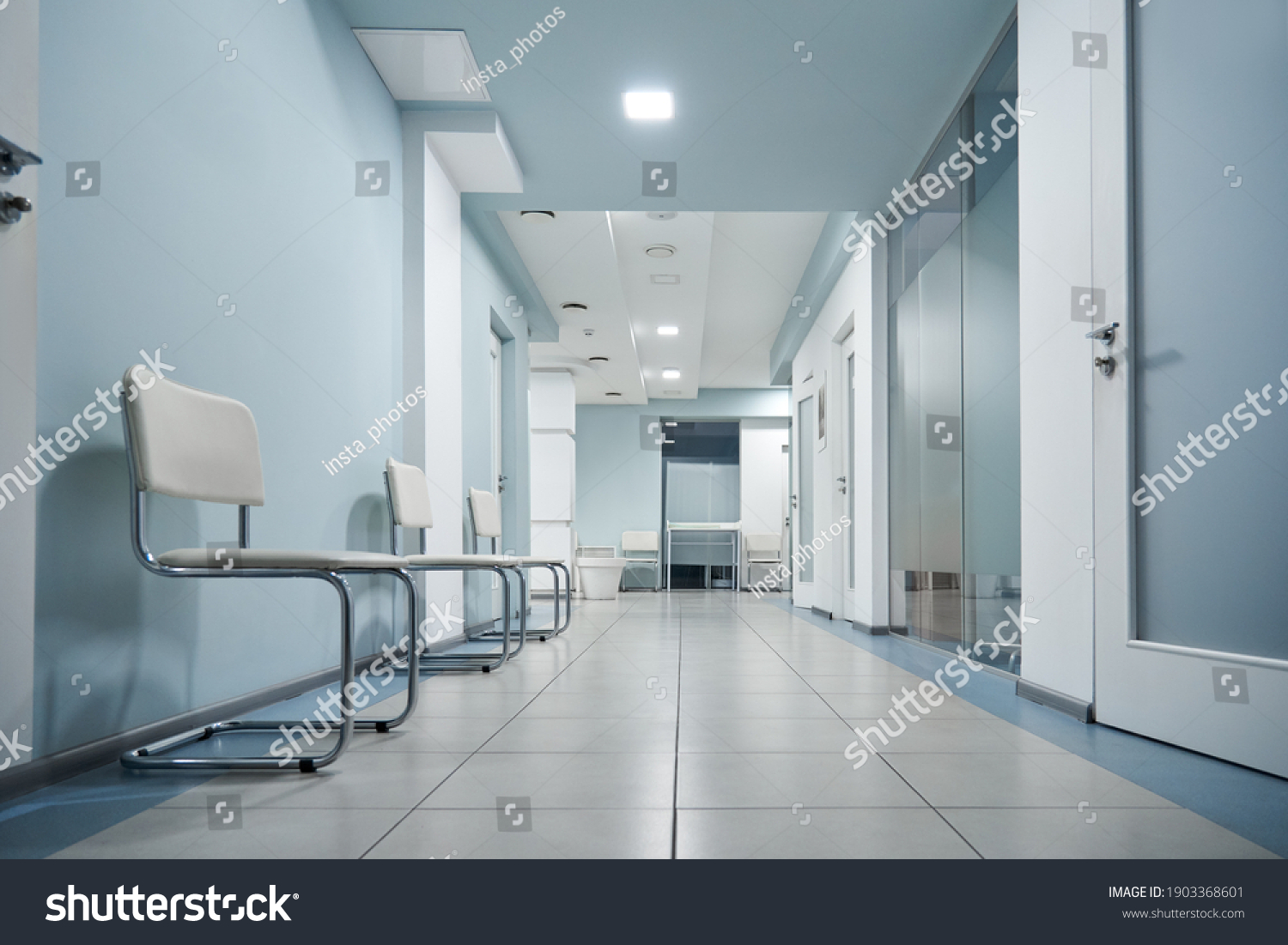 Empty modern hospital corridor, clinic hallway interior background with white chairs for patients waiting for doctor visit. Contemporary waiting room in medical office. Healthcare services concept #1903368601