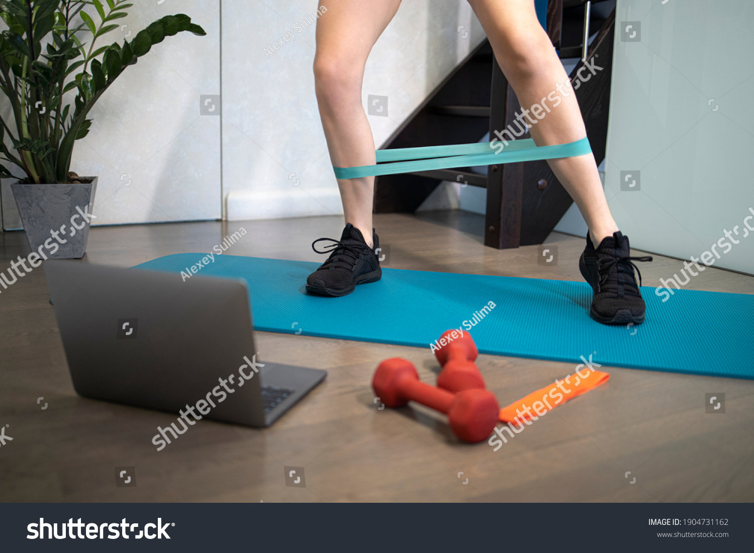 Young sporty slim woman has internet video online fitness training instructor modern laptop screen. Healthy lifestyle concept, online fitness and sport lessons. Exercises at home. #1904731162