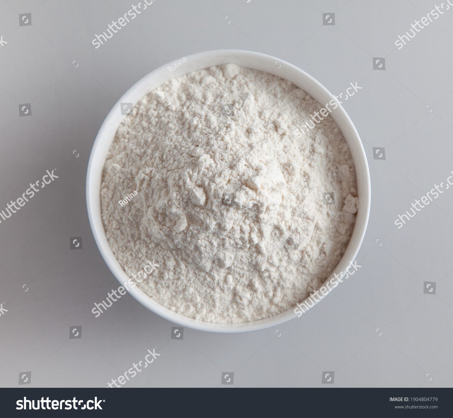 bowl of flour on grey kitchen table background, top view, selective focus #1904804779
