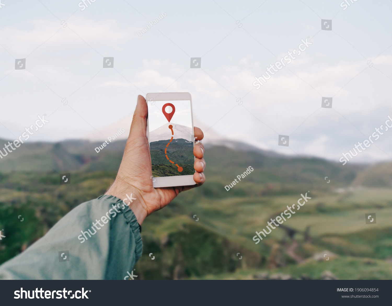 Traveler hiker man holding smartphone in a hand and using GPS app with trekking in summer mountains outdoor. Point of view in first person. #1906094854