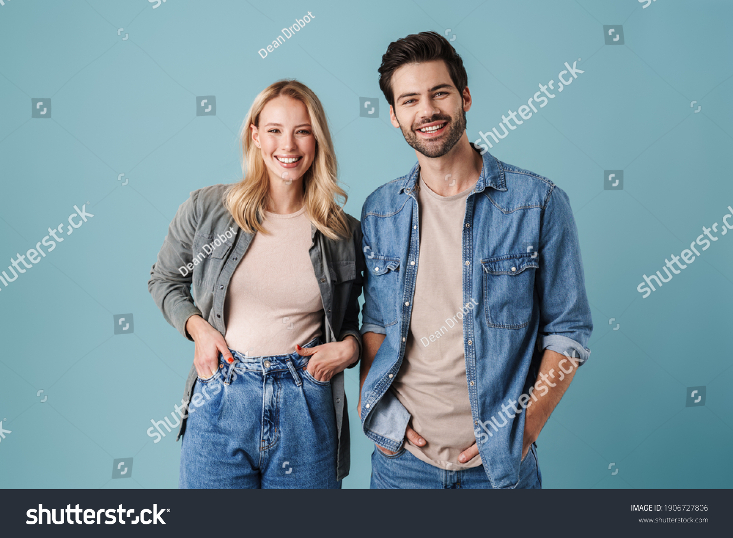 Young beautiful caucasian man and woman smiling and posing at camera isolated over blue background #1906727806