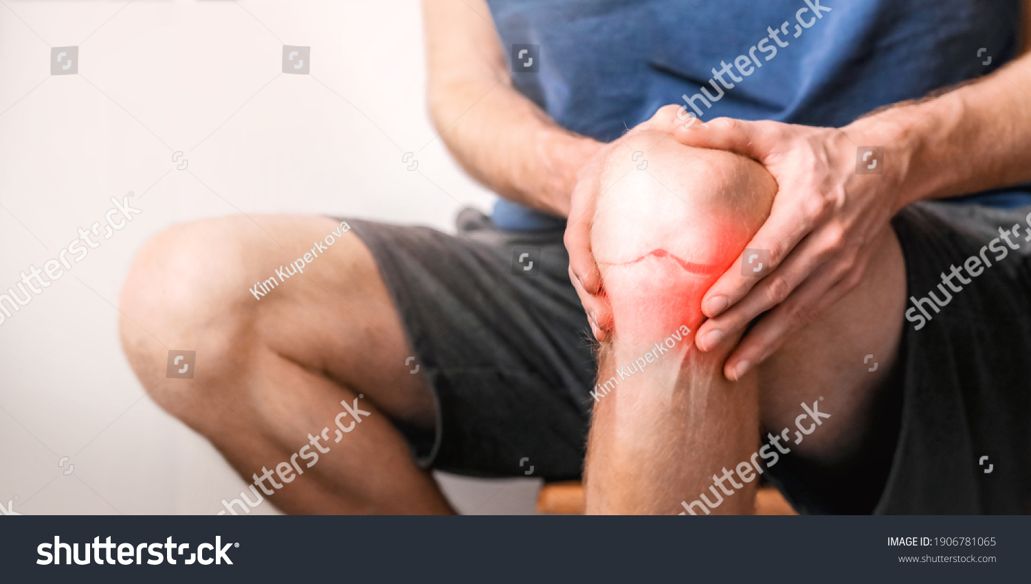 Young man suffering from knee pain at home, close up.  Joint inflammation concept.  #1906781065