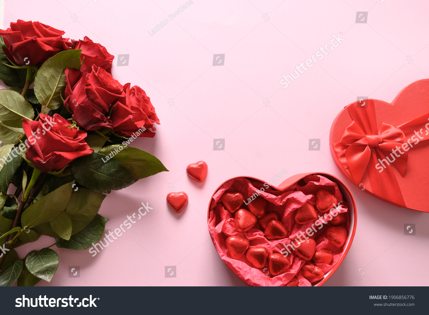 Red chocolate sweets and roses on pink for Valentine's day. Greeting card with copy space. #1906856776