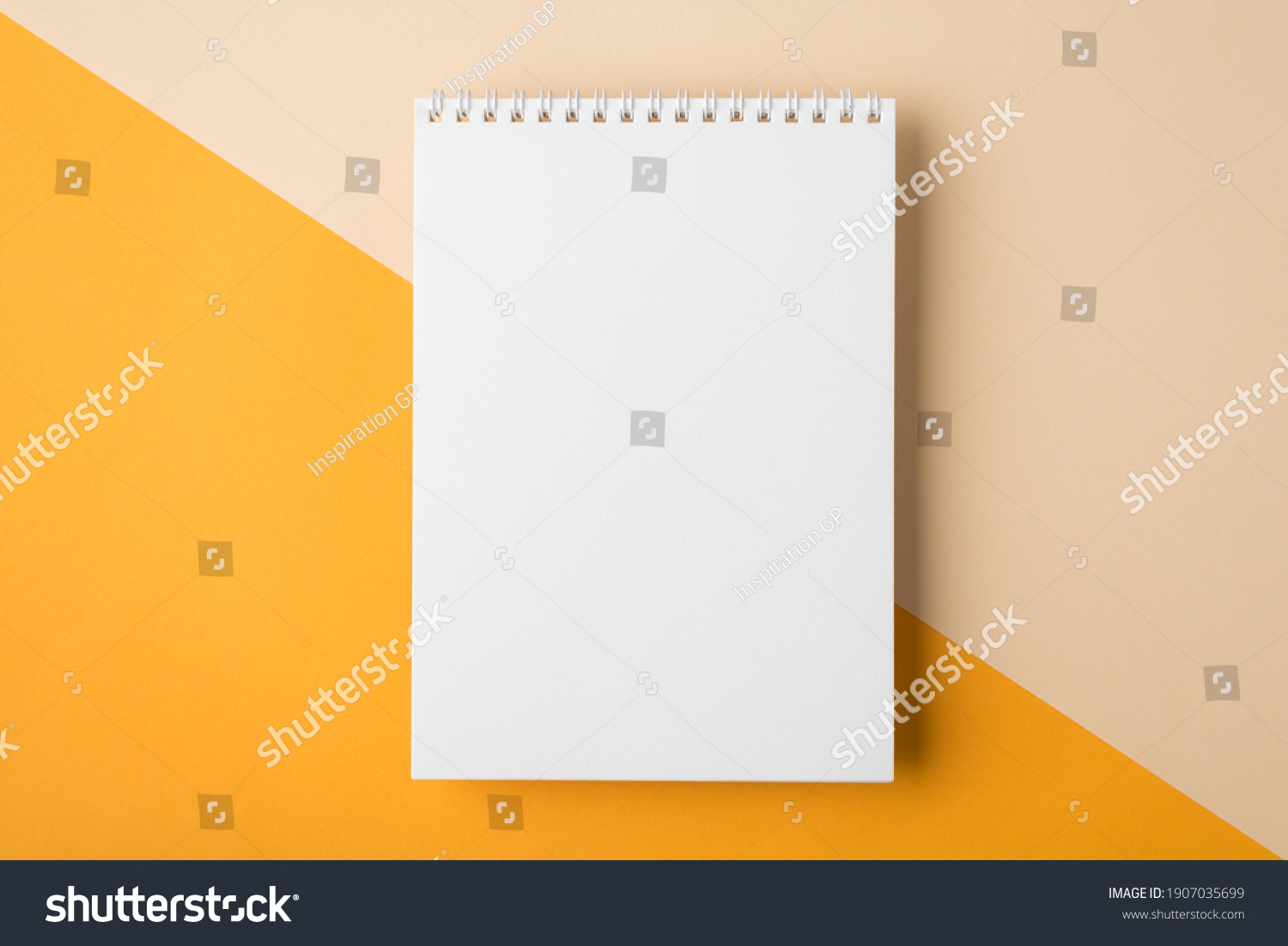 Minimal style note pad. Above overhead close up flat lay photo of clear spiral notepad with copy place for design isolated half yellow and beige backdrop desktop #1907035699