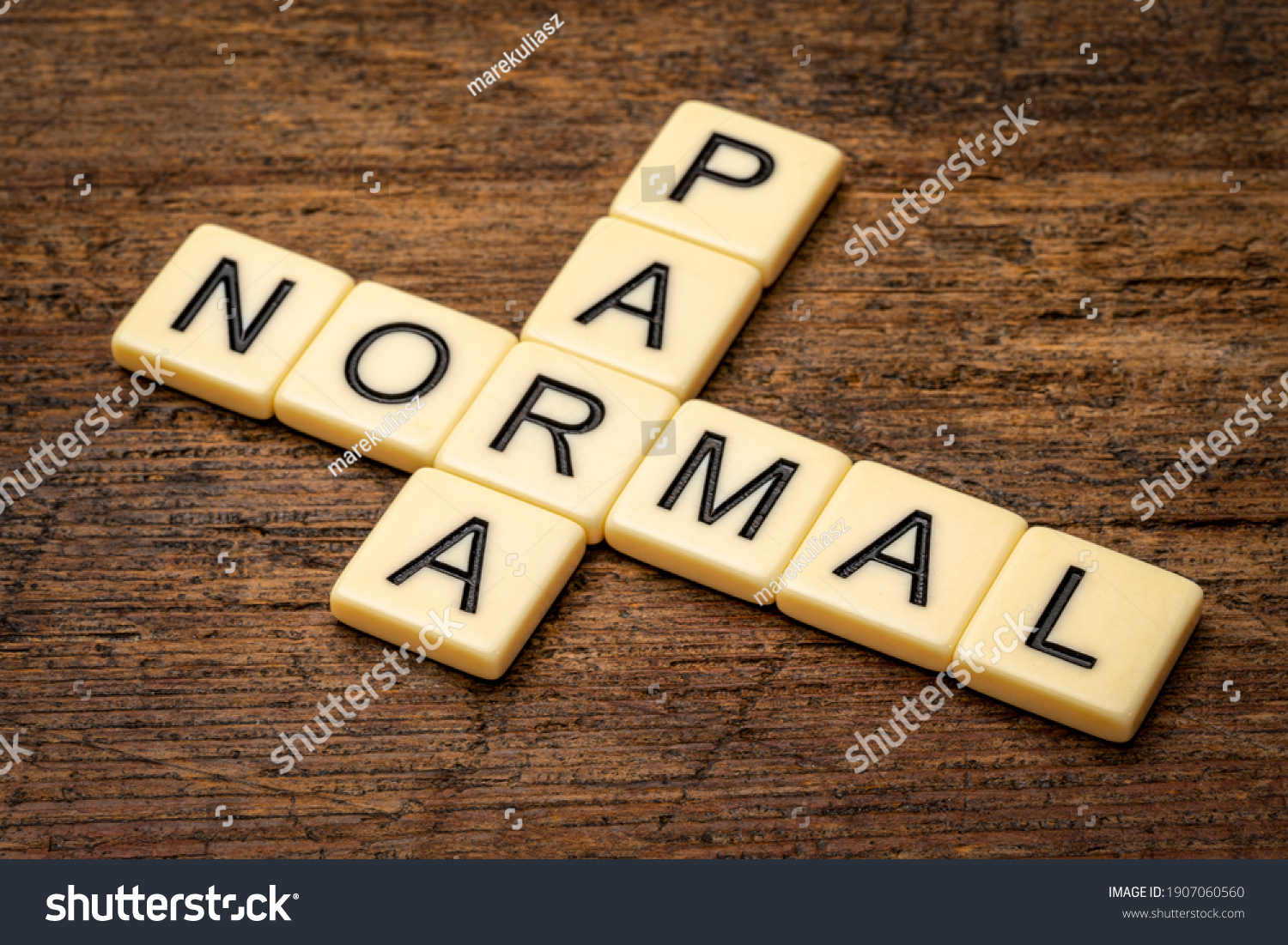 paranormal crossword in ivory letter tiles against rustic weathered wood, supernatural and unexplained phenomena #1907060560