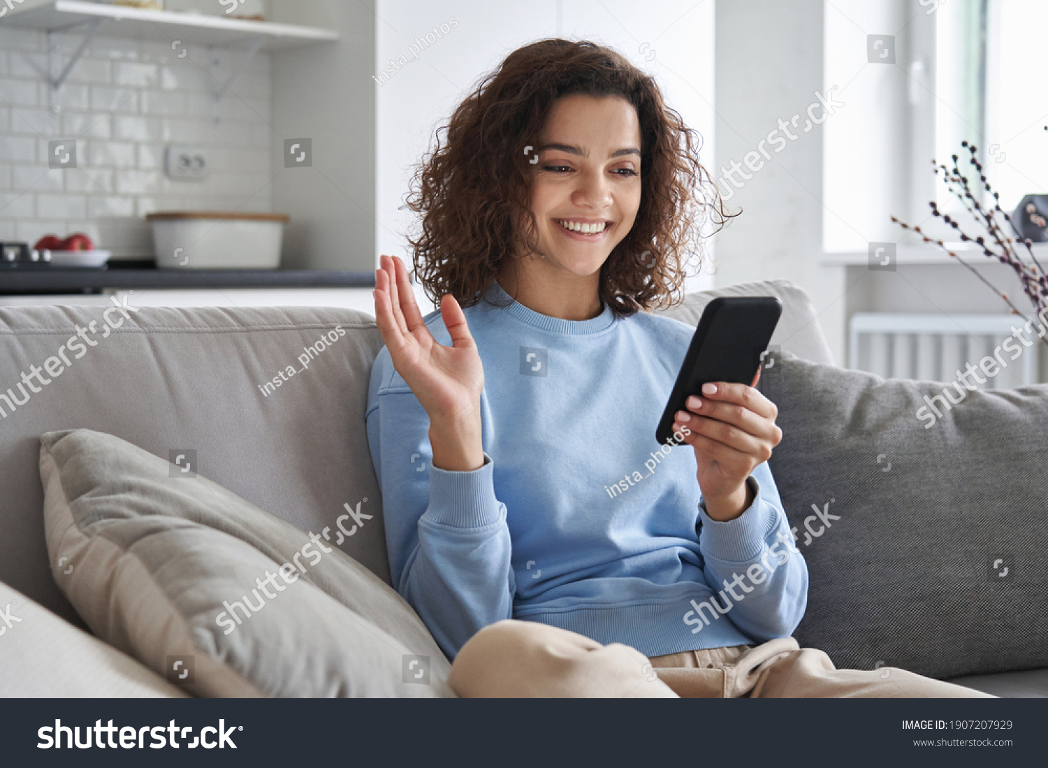 Happy hispanic teen girl waving hand using smartphone app enjoying online virtual chat video call with friends in distance mobile chat virtual meeting, recording stories for social media at home. #1907207929