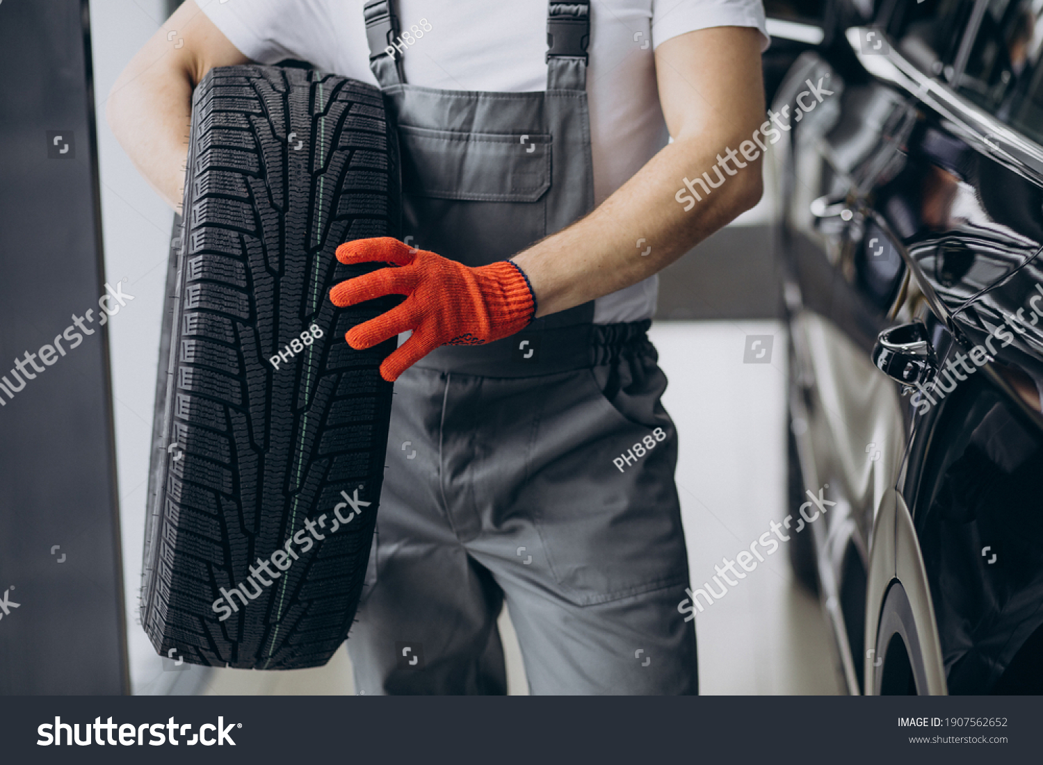 Mechanic changing tires in a car service #1907562652