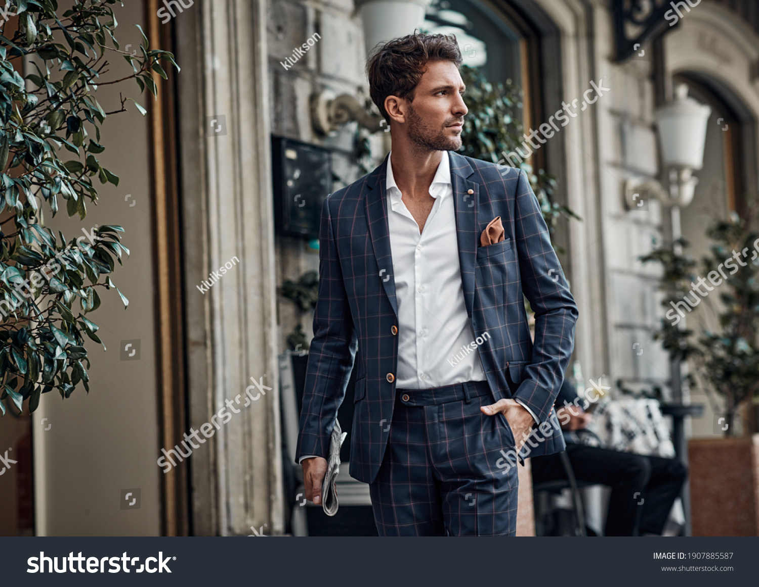 Handsome male model in checked suit walking on the street #1907885587
