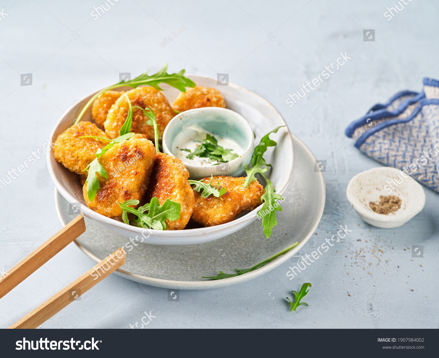 Vegetarian Nuggets with Vegan Dipping Sauce and rocket leaves on a light background with space for text, selective focus. Healthy Diet, Protein Vegetarian Meals concept, alternative meat products. #1907984002