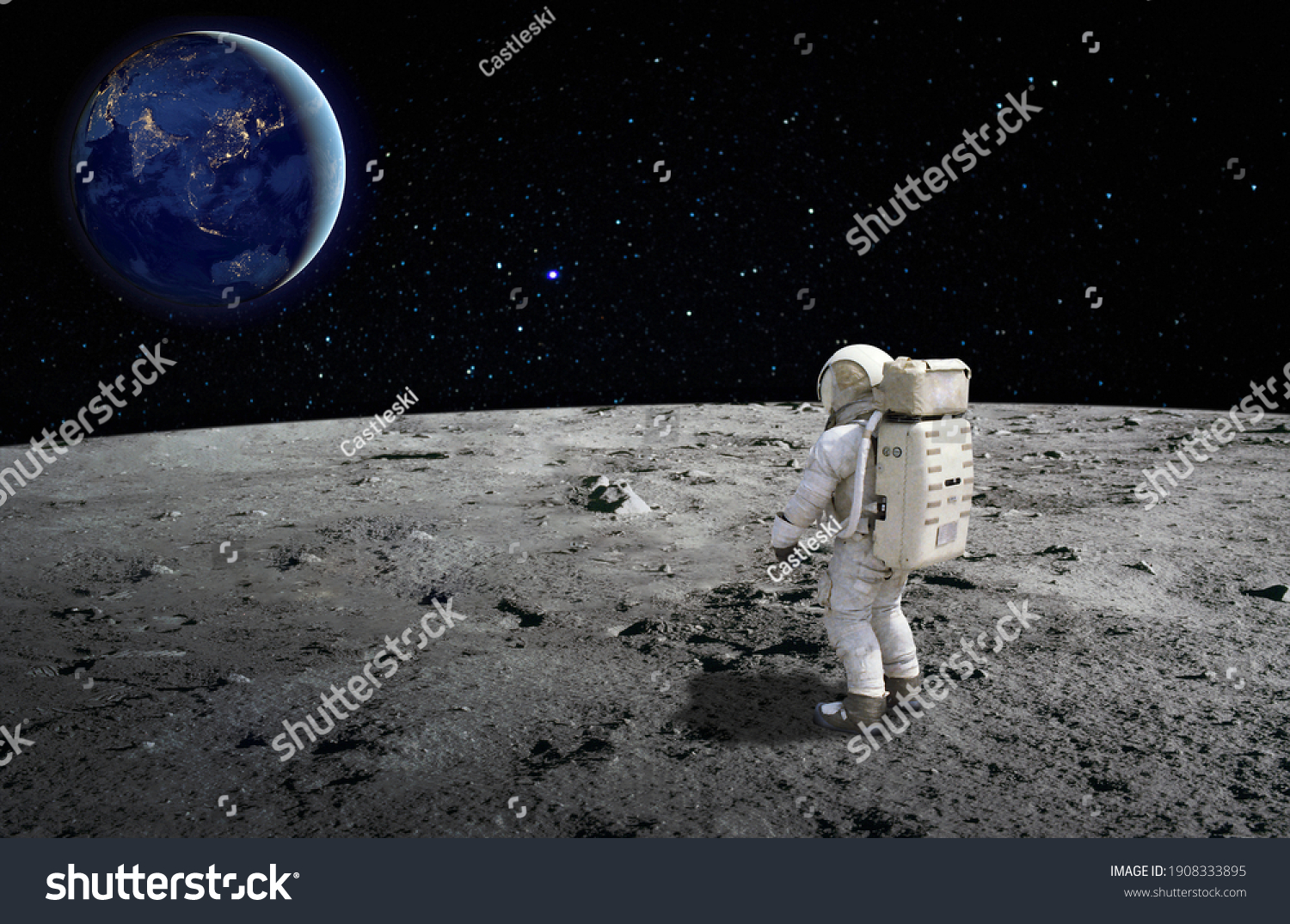 An astronaut standing on the surface of the moon looking up to the earth on the background. Elements of this image furnished by NASA. #1908333895