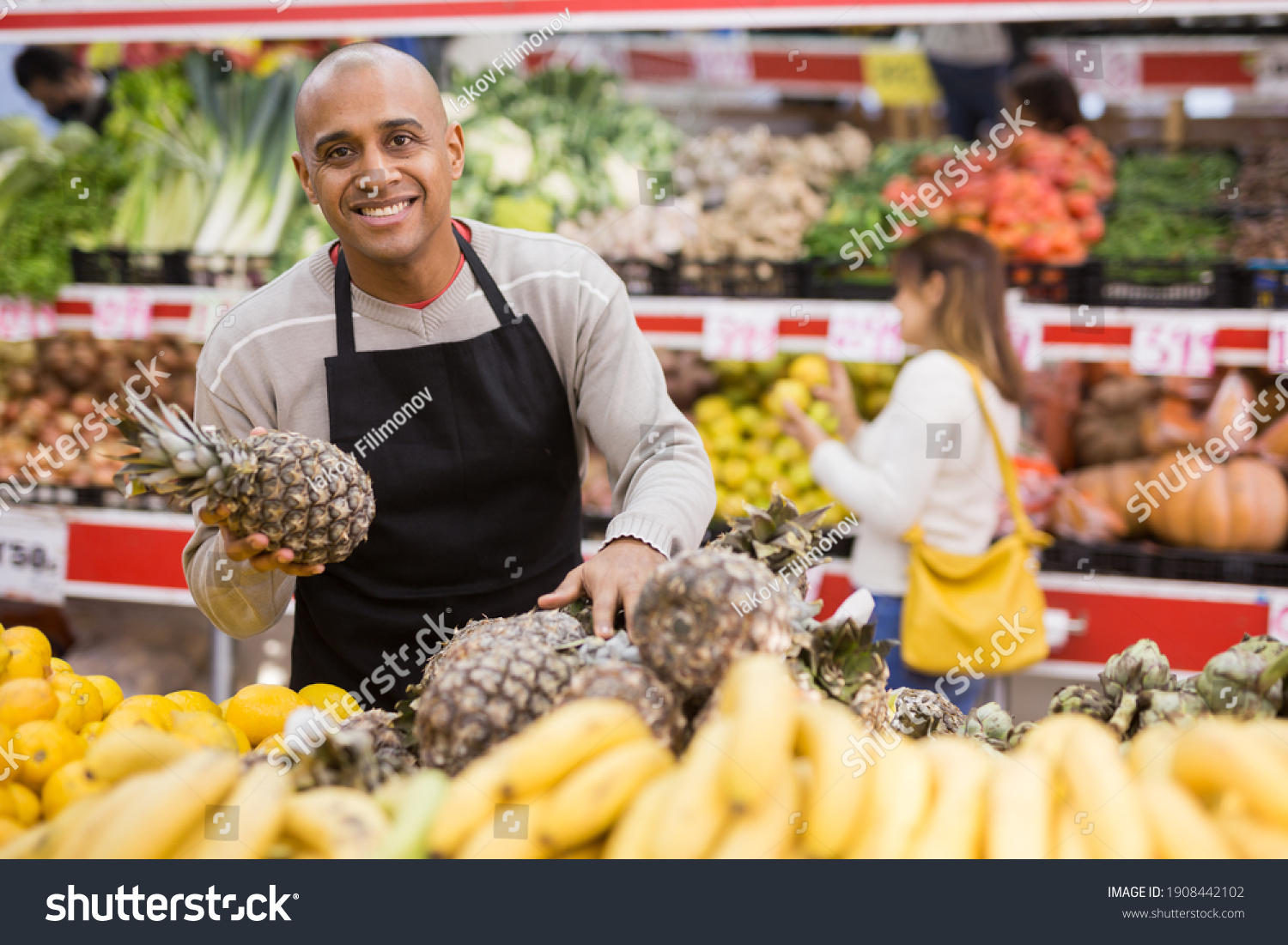 Portrait of latino-american worker in supermarket with pineapples #1908442102