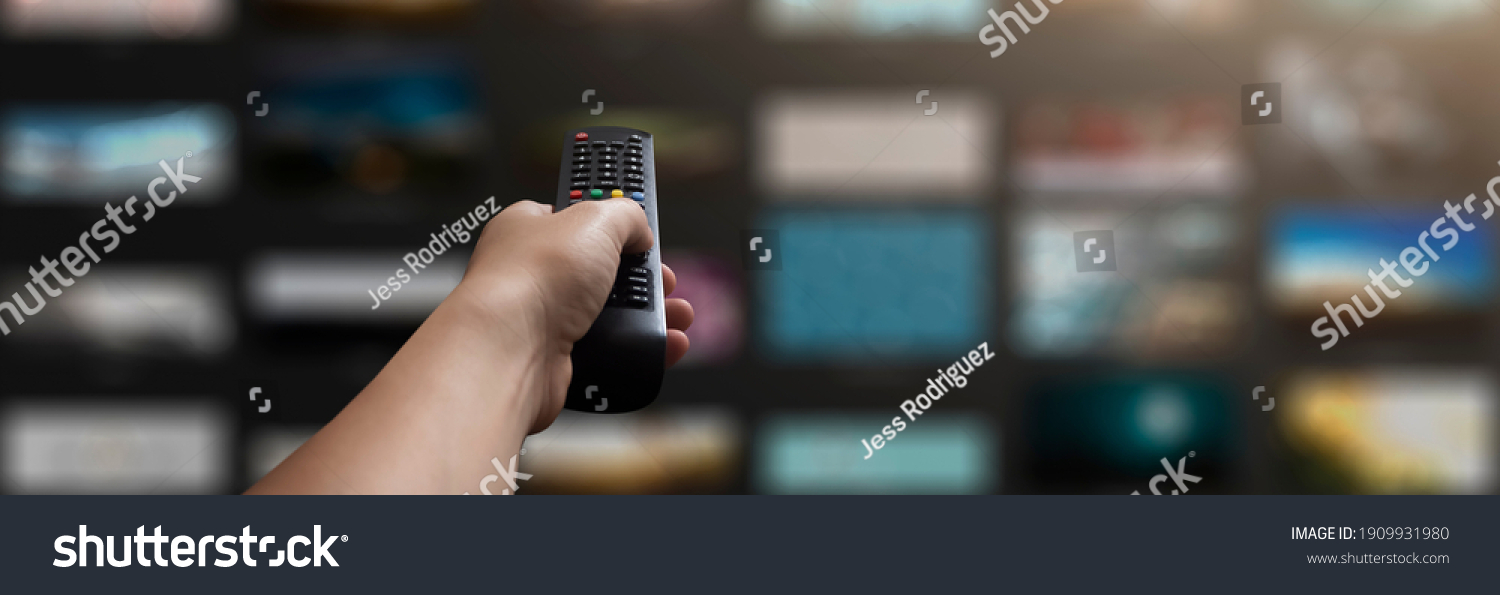 concept - man with his remote control watching tv in his living room #1909931980