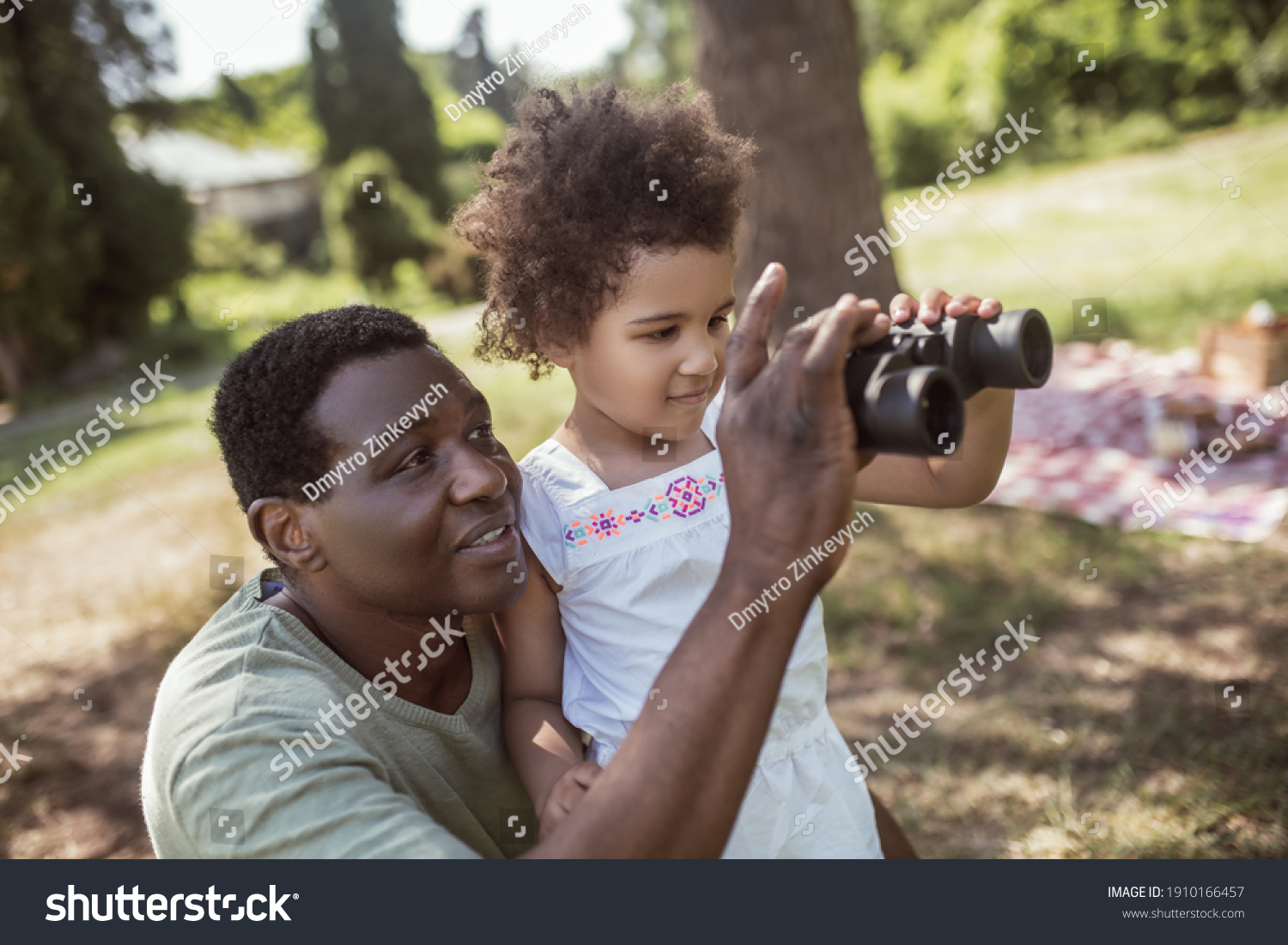 New experience. Dark-skinned cute girl holding a binocular and looking interested #1910166457