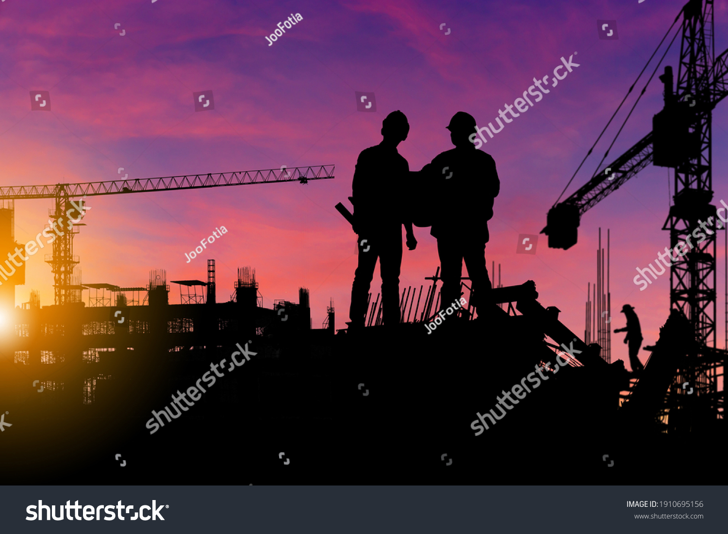 Silhouette of Engineer and worker checking project at building site background, construction site at sunset in evening time #1910695156