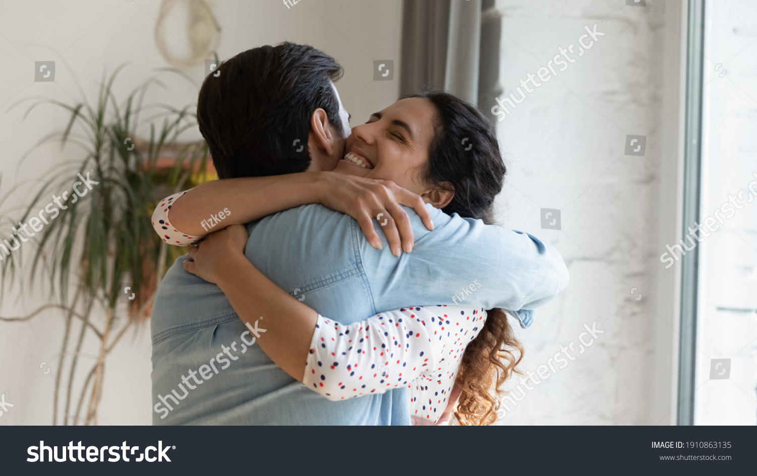 In your warm embraces. Excited wife holding beloved husband tight in arms grateful for support love care. Young couple hug reconciling after family fight or missing each other spending long time apart #1910863135