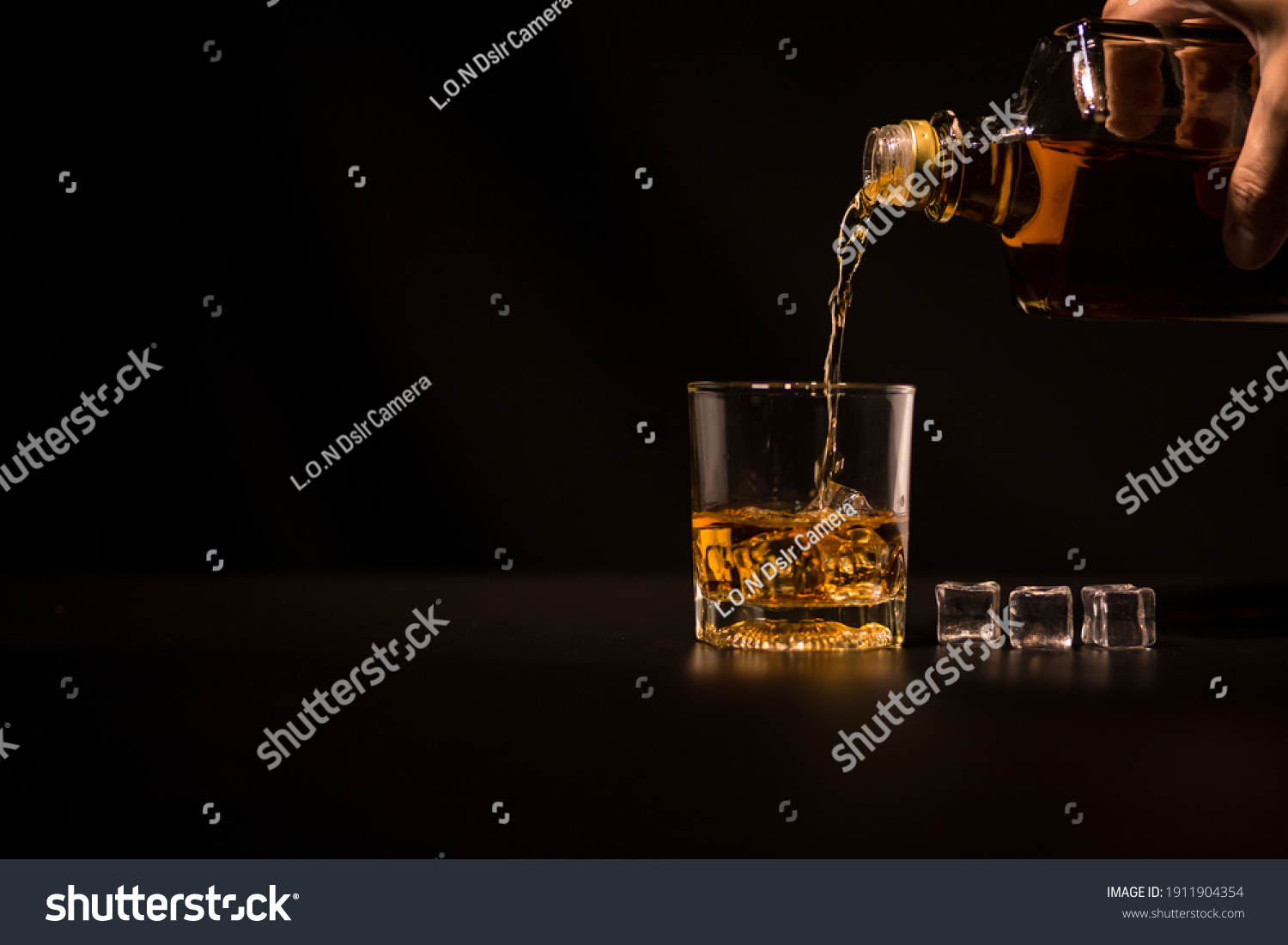 Closeup Barman pouring whiskey into glass #1911904354