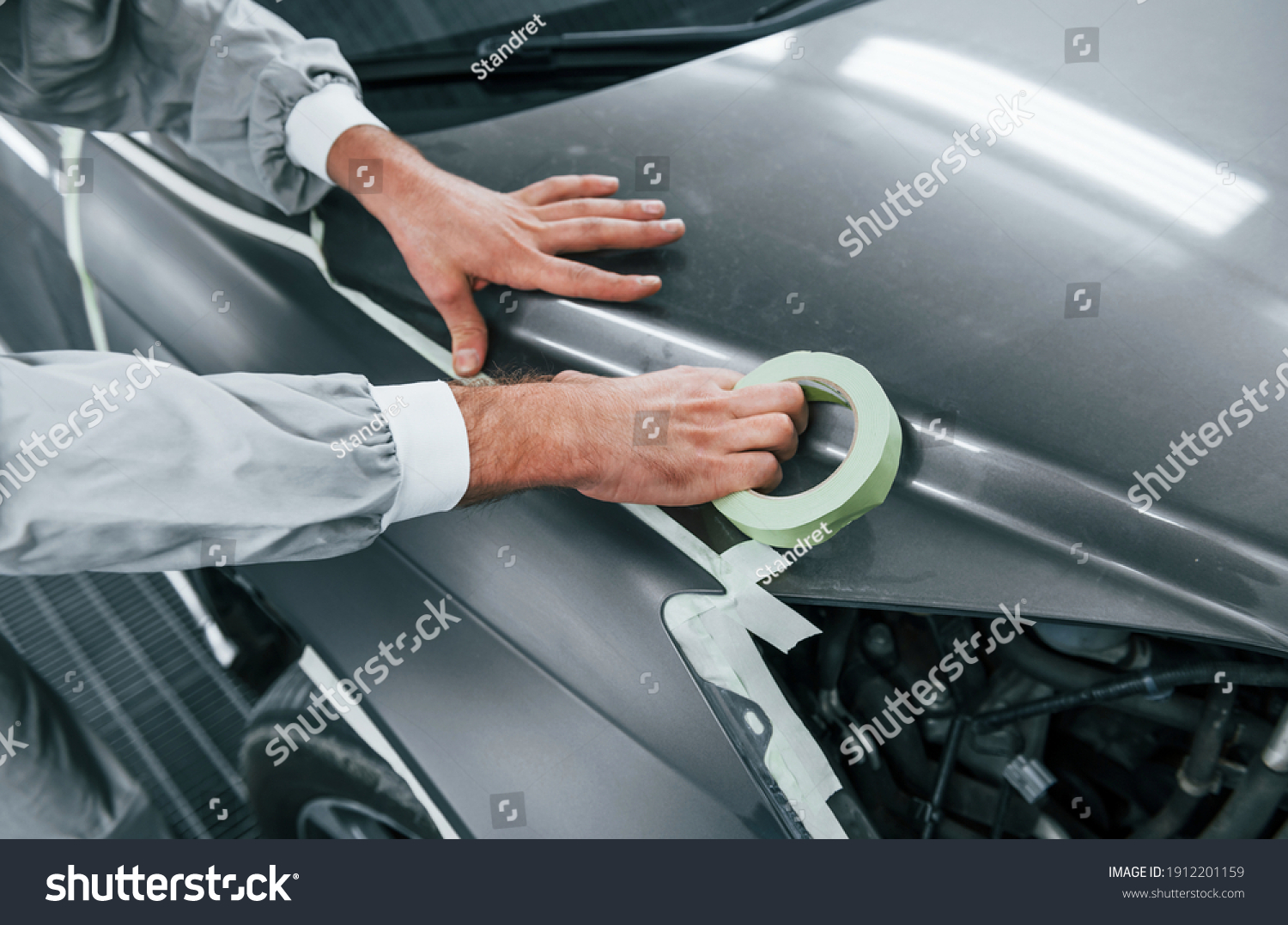 Detailed work. Caucasian automobile repairman in uniform have job in garage. #1912201159