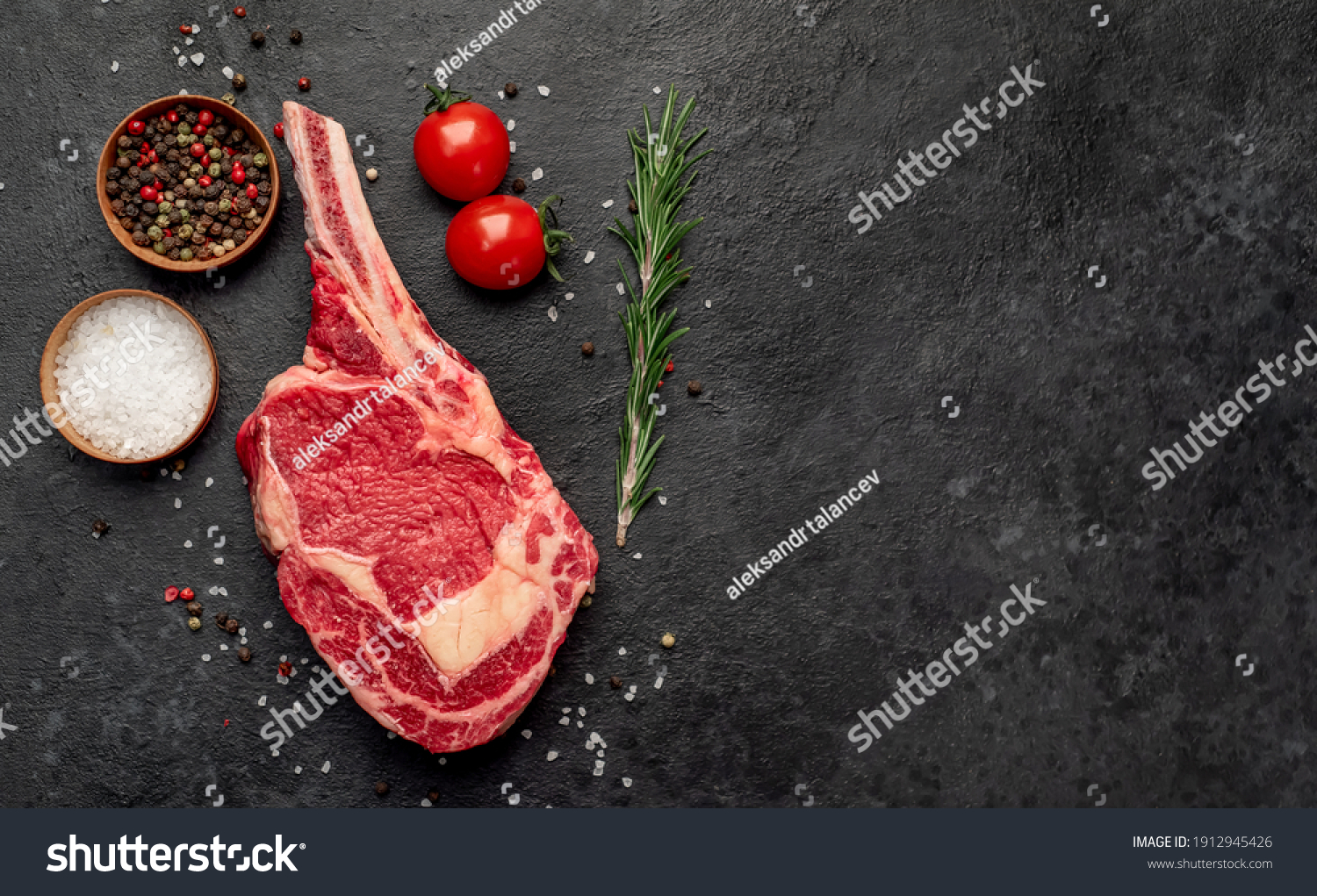 Raw cowboy steak with spices on stone background #1912945426