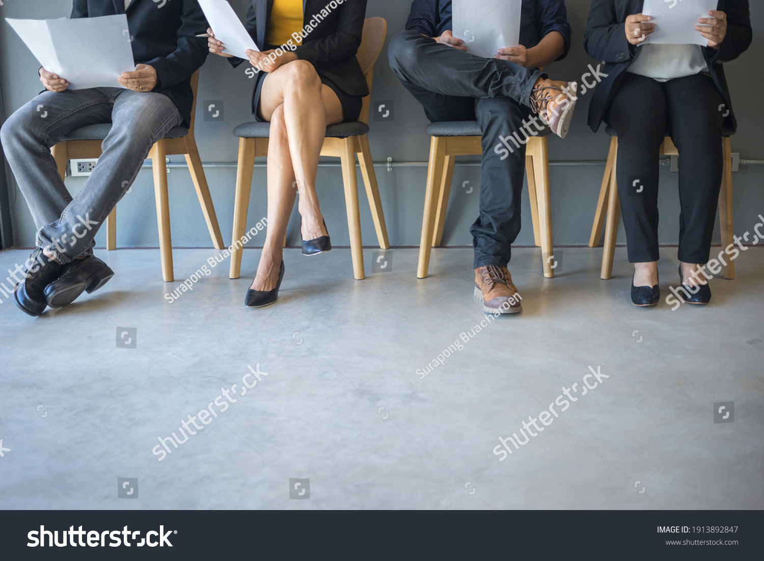 Group of peoples are sitting to review the documents while waiting for a job interview. #1913892847