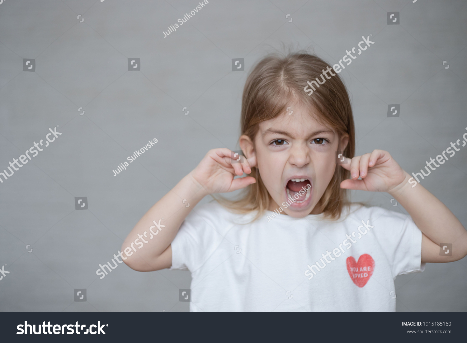 Portrait of little girl with her ears blocked - Royalty Free Stock ...