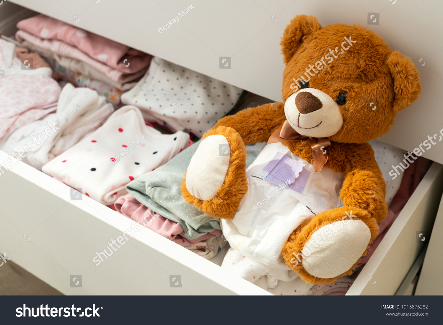 Pcture of a brown teddy bear with diaper on sitting in baby bed #1915876282