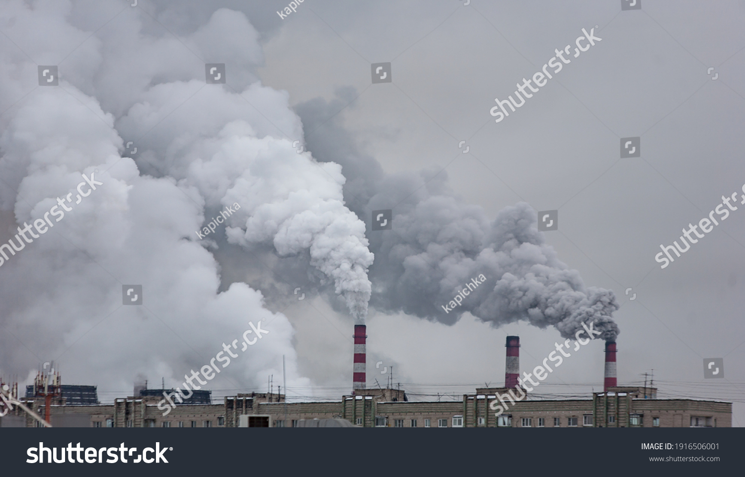 industrial chimneys with heavy smoke causing air pollution on the gray smoky sky background #1916506001