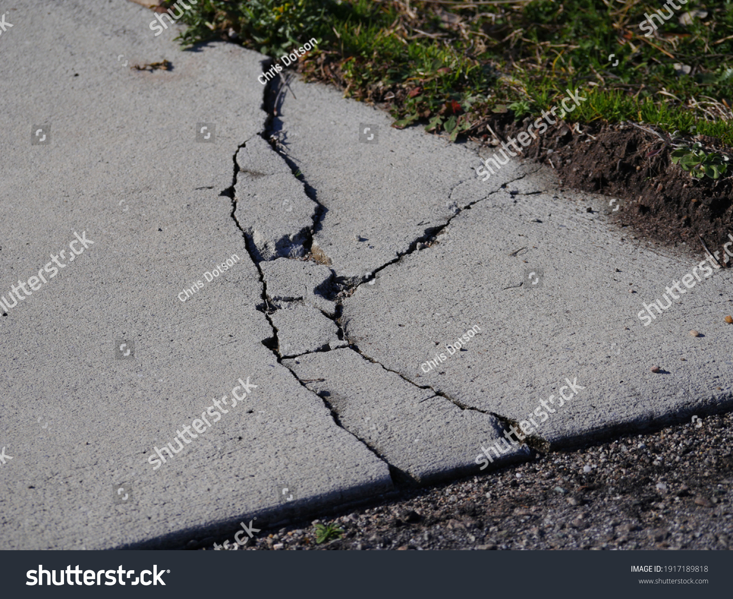 Cracks in concrete driveway, sunken areas caused by heavy equipment or settling #1917189818