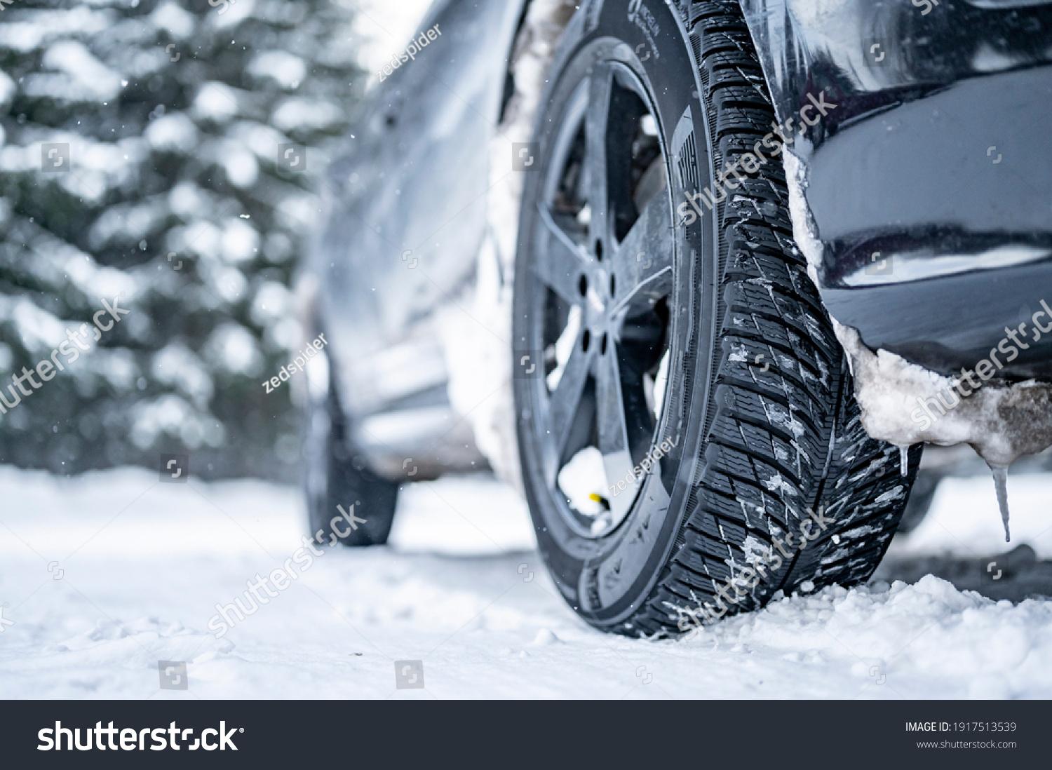 Winter tire. Detail of car tires in winter on the road covered with snow. #1917513539