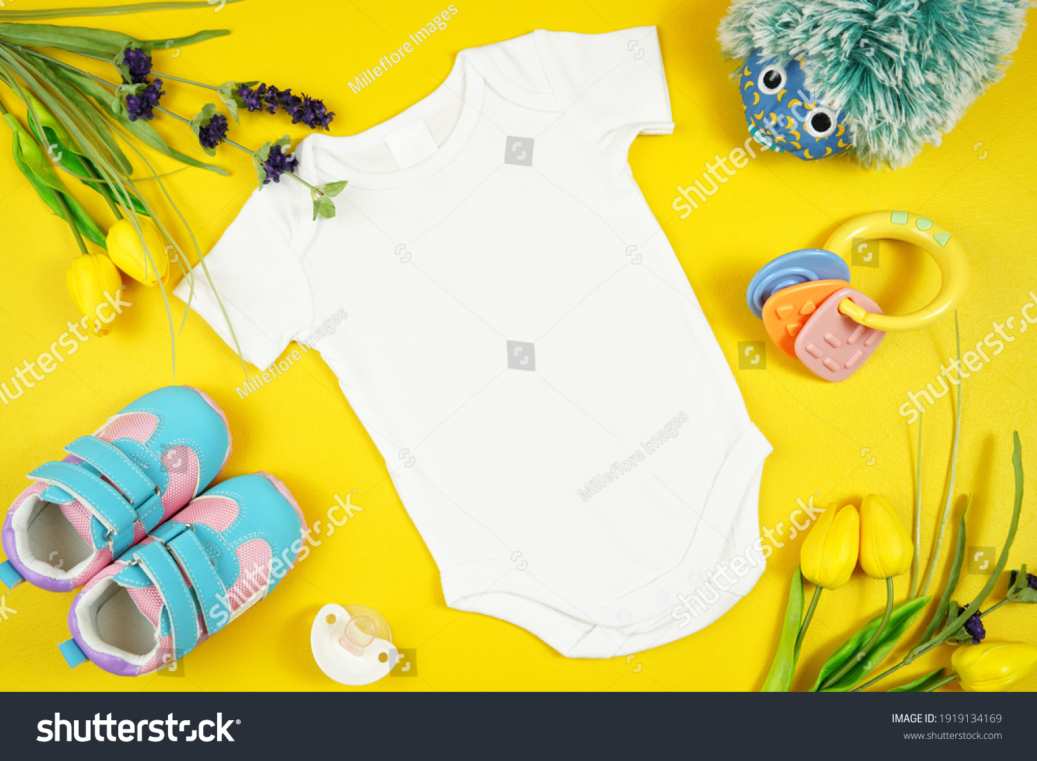 Springtime baby apparel flatlay on bright yellow table with colorful accessories. Mock up with negative copy space for your text or design here. #1919134169