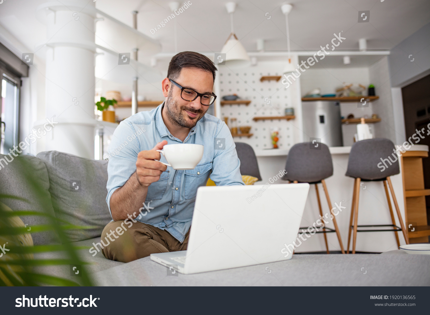 Man  rest on sofa put notebook on lap looking at screen watching movie enjoy lazy free day, creates blog, booking on-line, buyer choose goods makes order, shopping in internet lifestyle concept #1920136565
