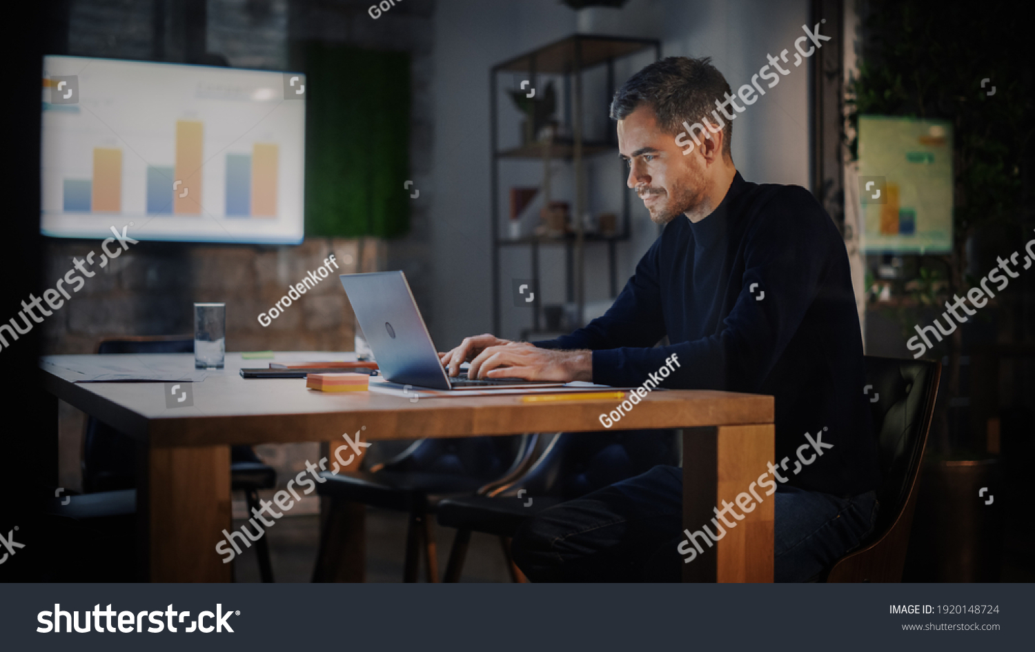 Handsome Caucasian Male is Working on Laptop Computer while Sitting Behind a Conference Table in Meeting Room in an Creative Agency. Project Manager is Busy With Business Strategy and Development. #1920148724