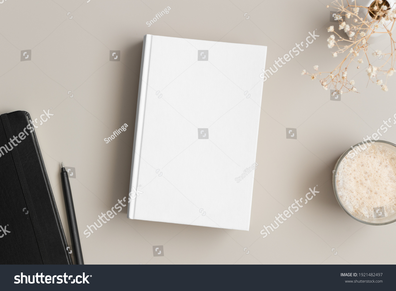 White book mockup with a gypsophila, coffee and workspace accessories on a beige table. #1921482497
